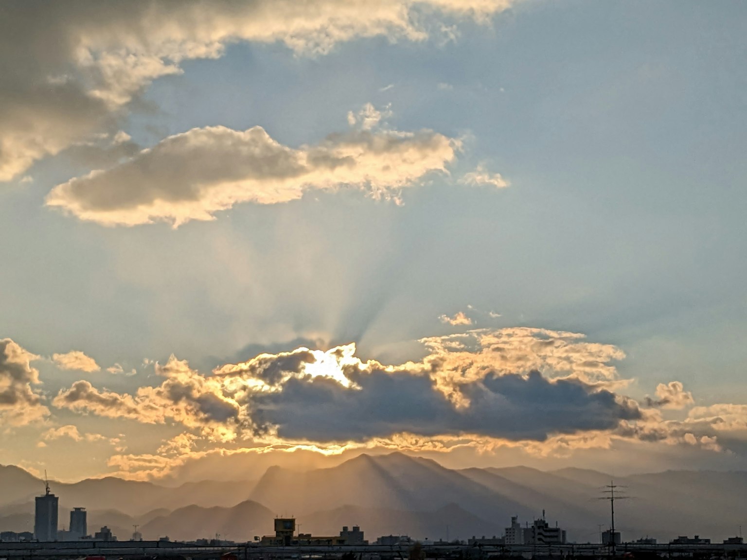 Cielo al tramonto con nuvole e silhouette di montagne