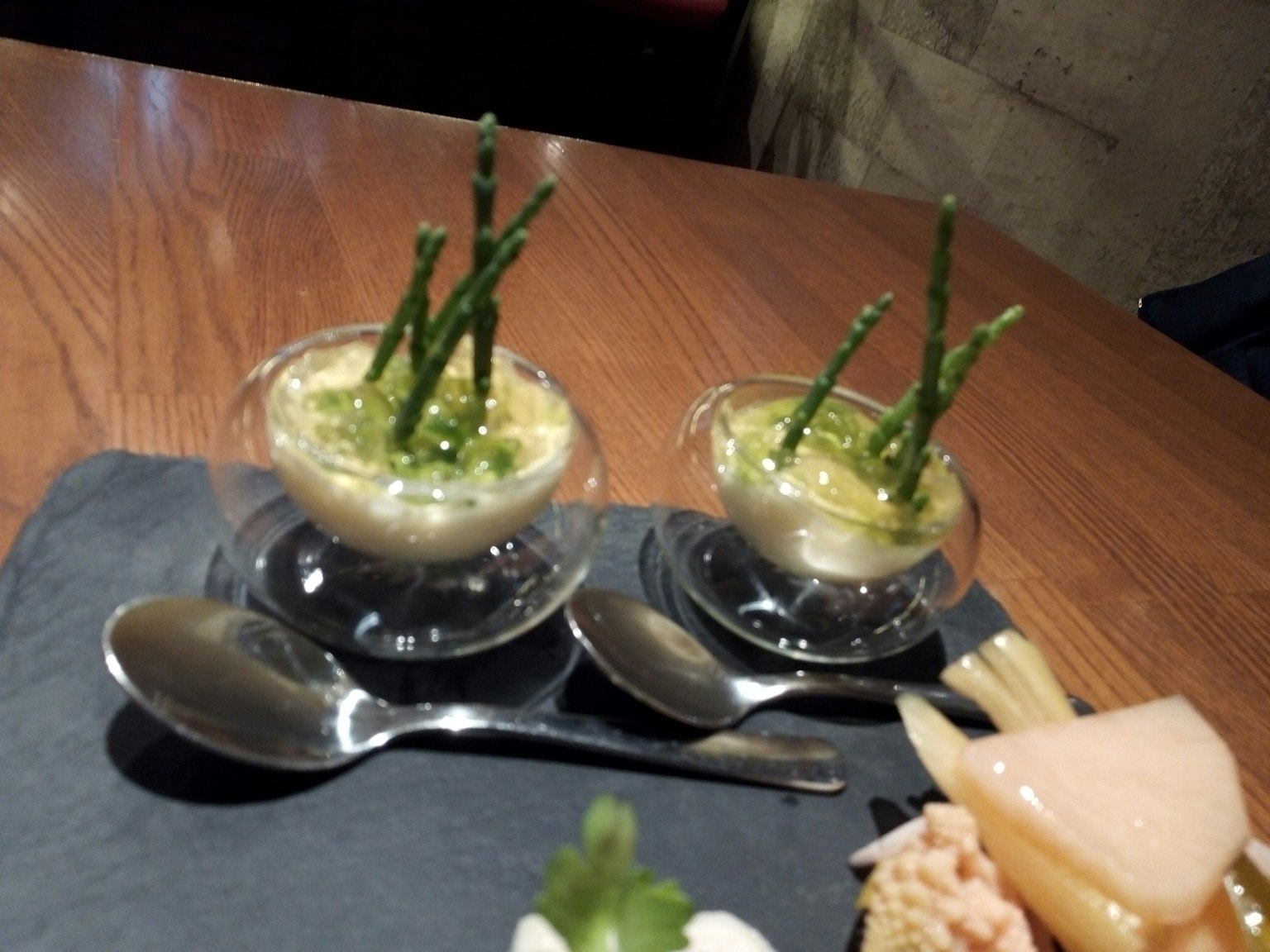 Zuppa cremosa di asparagi in tazze trasparenti guarnita con punte di asparagi