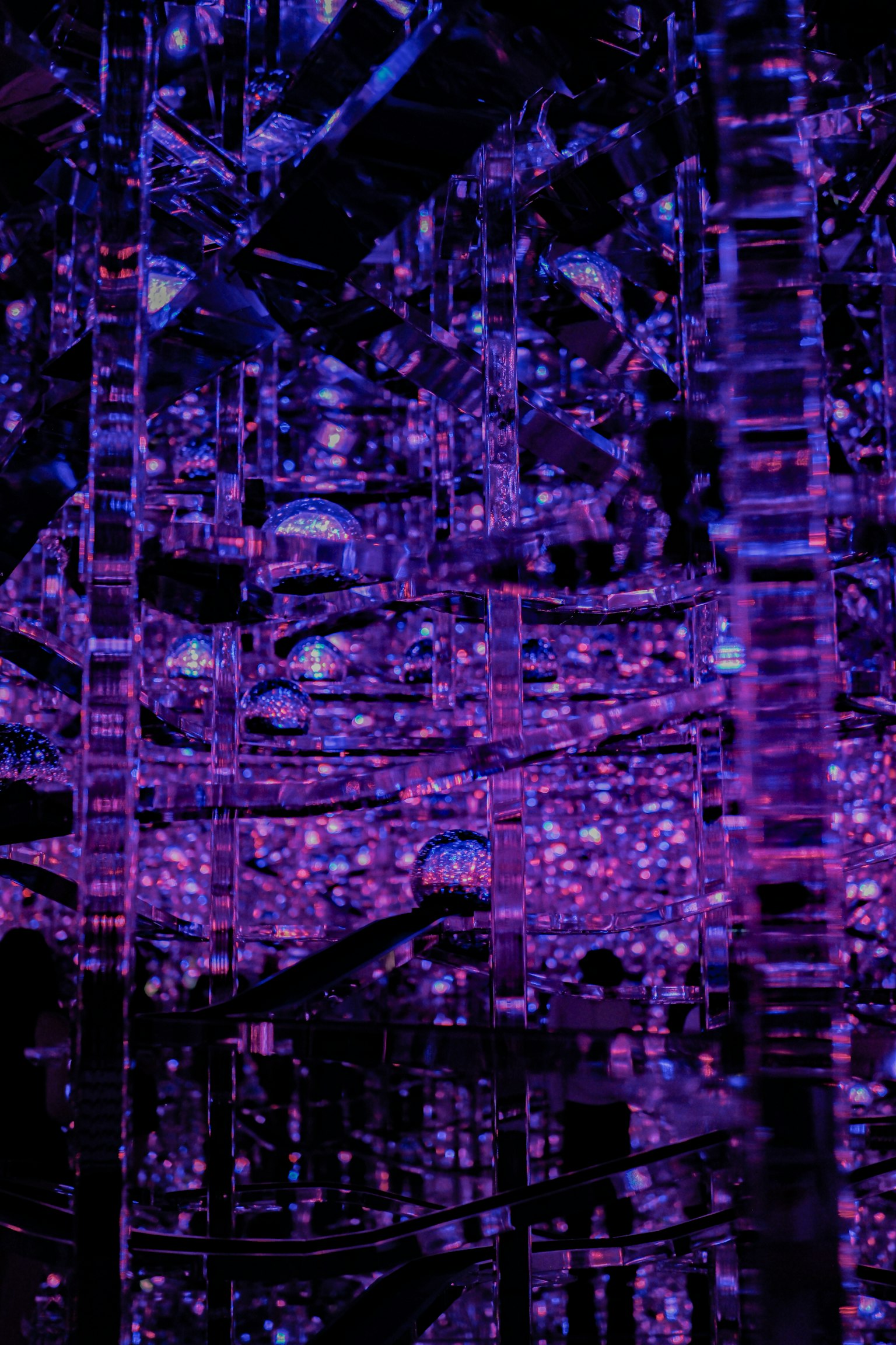 Intérieur d'une structure miroir complexe reflétant une lumière violette