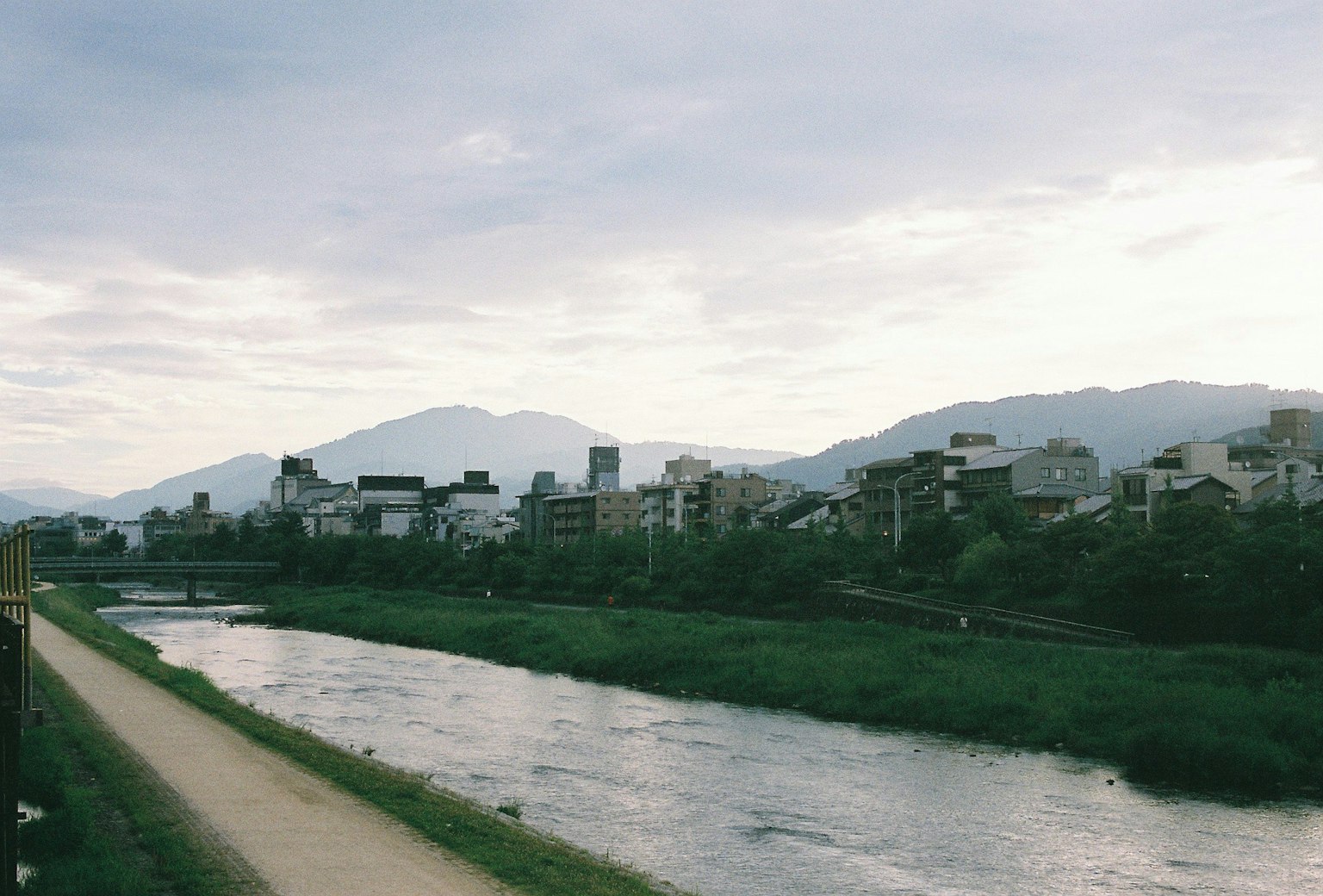 Image of a cityscape surrounded by river and mountains