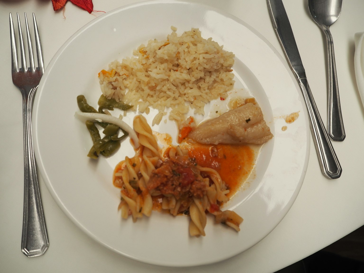 Un plato con arroz, pasta, pollo y verduras verdes