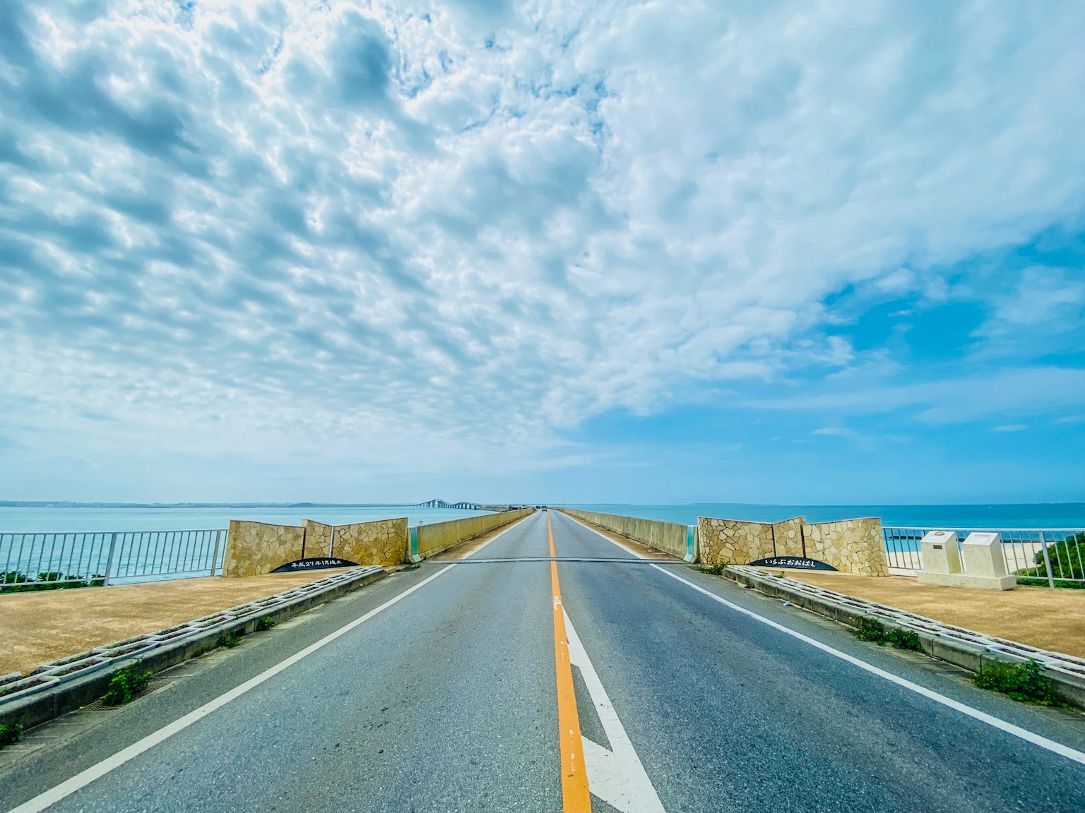 Malersicher Weg, der zum Meer führt, unter einem blauen Himmel mit Wolken