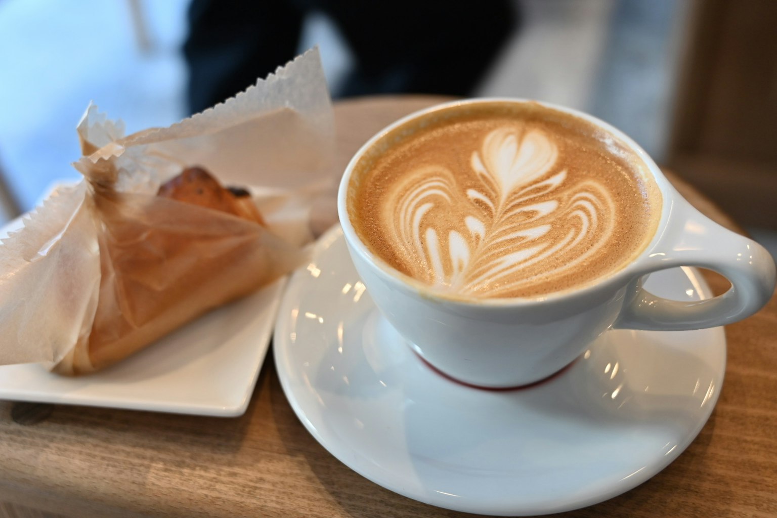 Kopi latte dengan kue di atas meja kayu