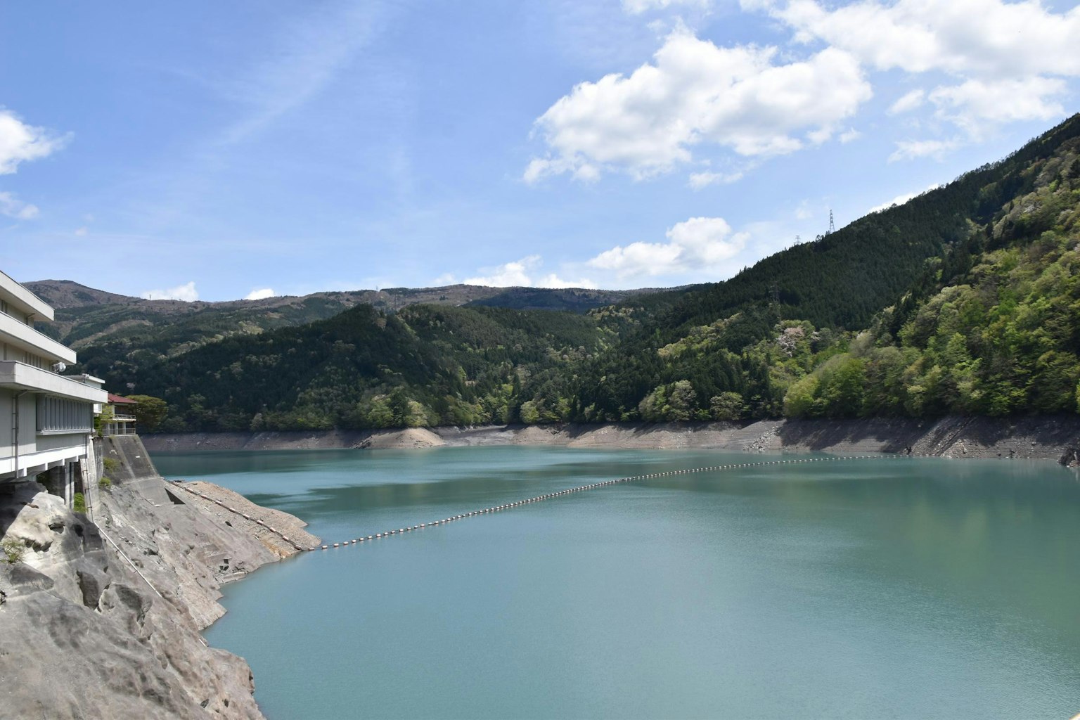 A serene blue lake surrounded by green hills under a clear sky