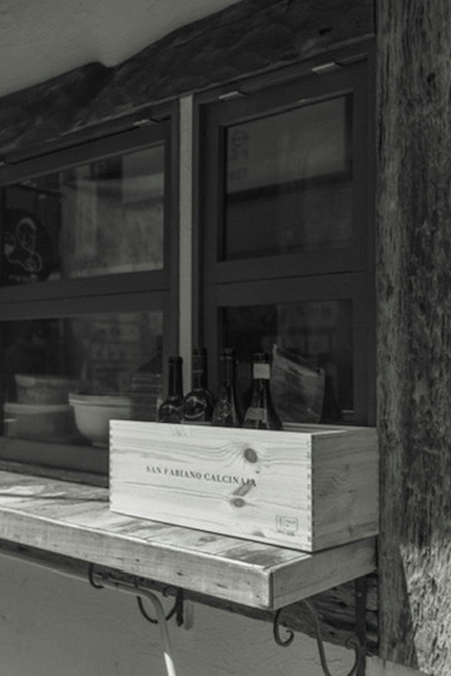 Une boîte en bois avec des bouteilles exposées sur un rebord de fenêtre