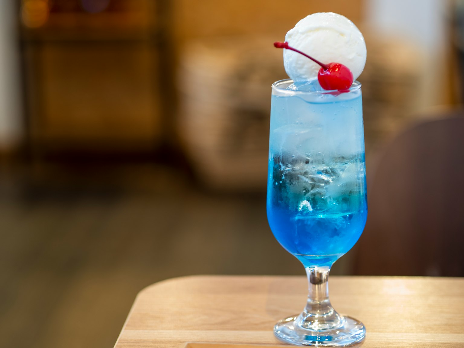 Cocktail bleu surmonté de crème glacée et d'une cerise