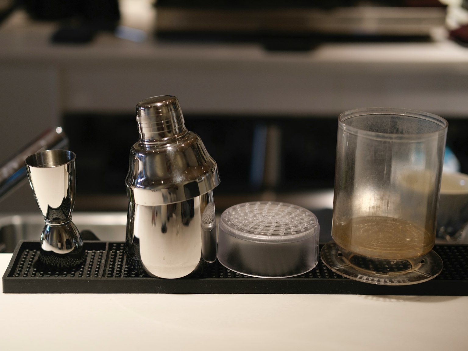 Shaker cocktail jigger bộ lọc và cốc được sắp xếp trên quầy bar