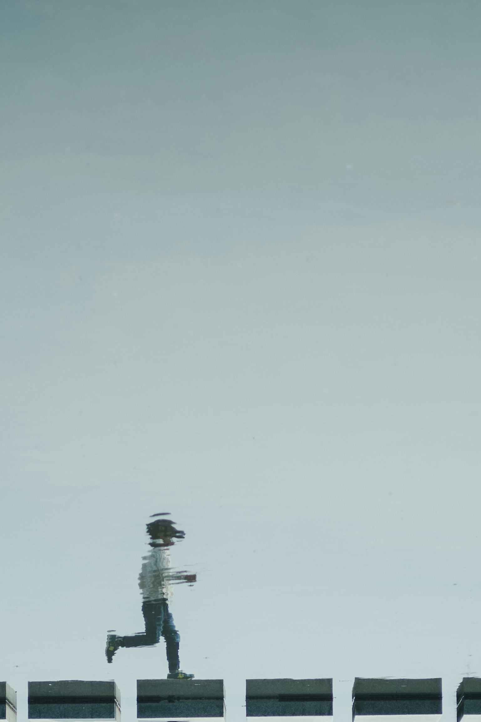 Niño corriendo sobre bloques rectangulares bajo un cielo azul