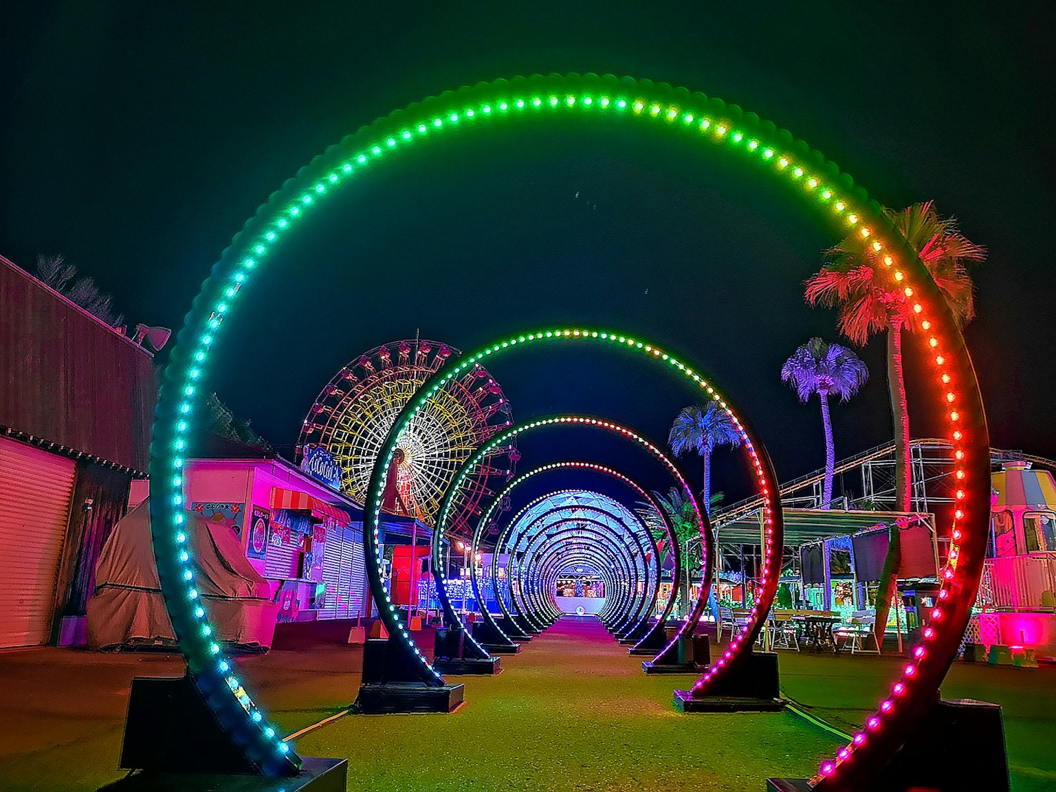 Una vivace esposizione di archi illuminati di notte in un luna park
