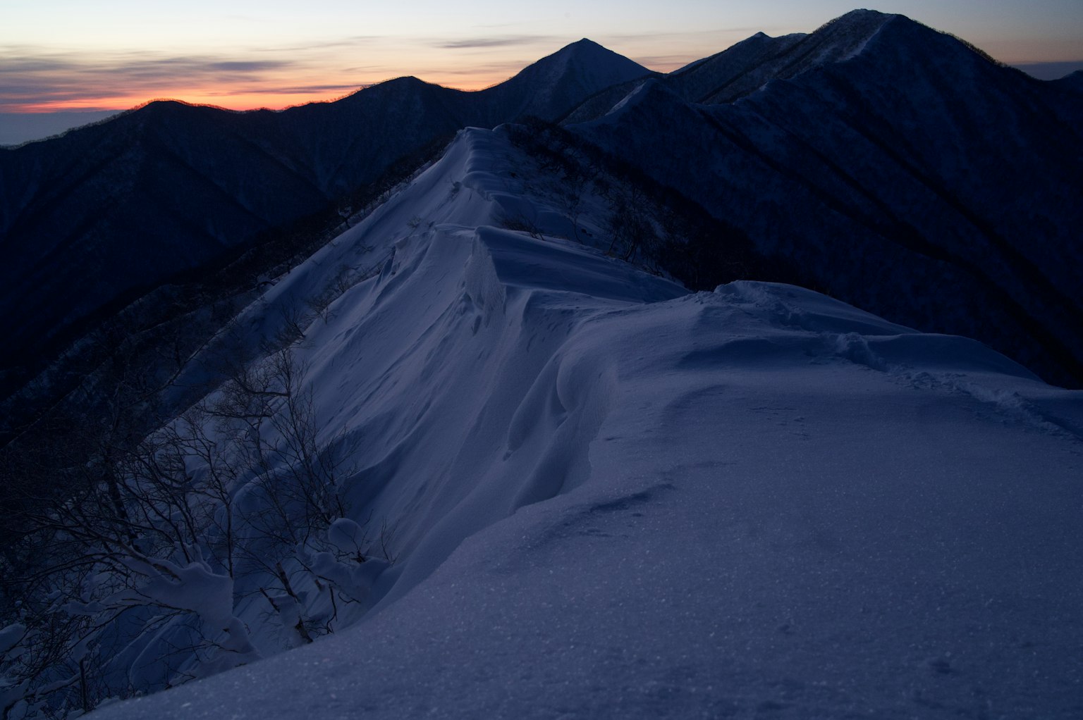 Crête montagneuse enneigée avec ciel au coucher de soleil