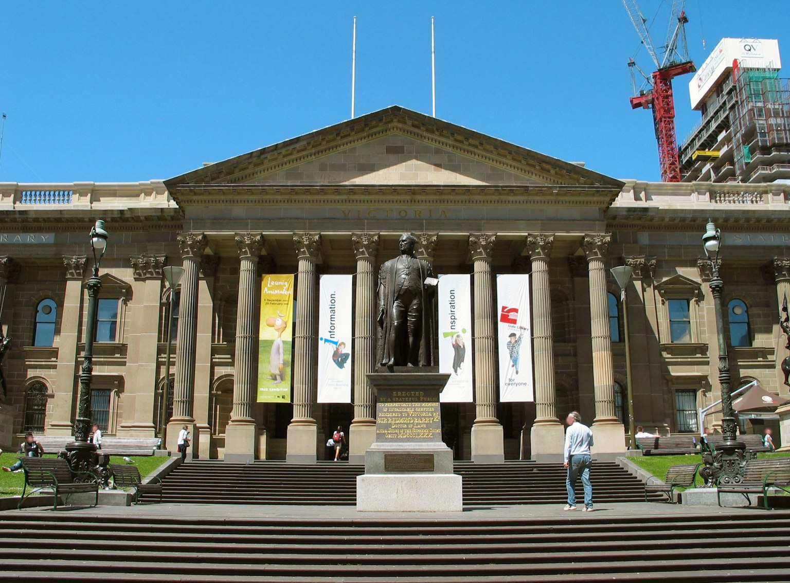 Historic building with a statue and banners in the foreground
