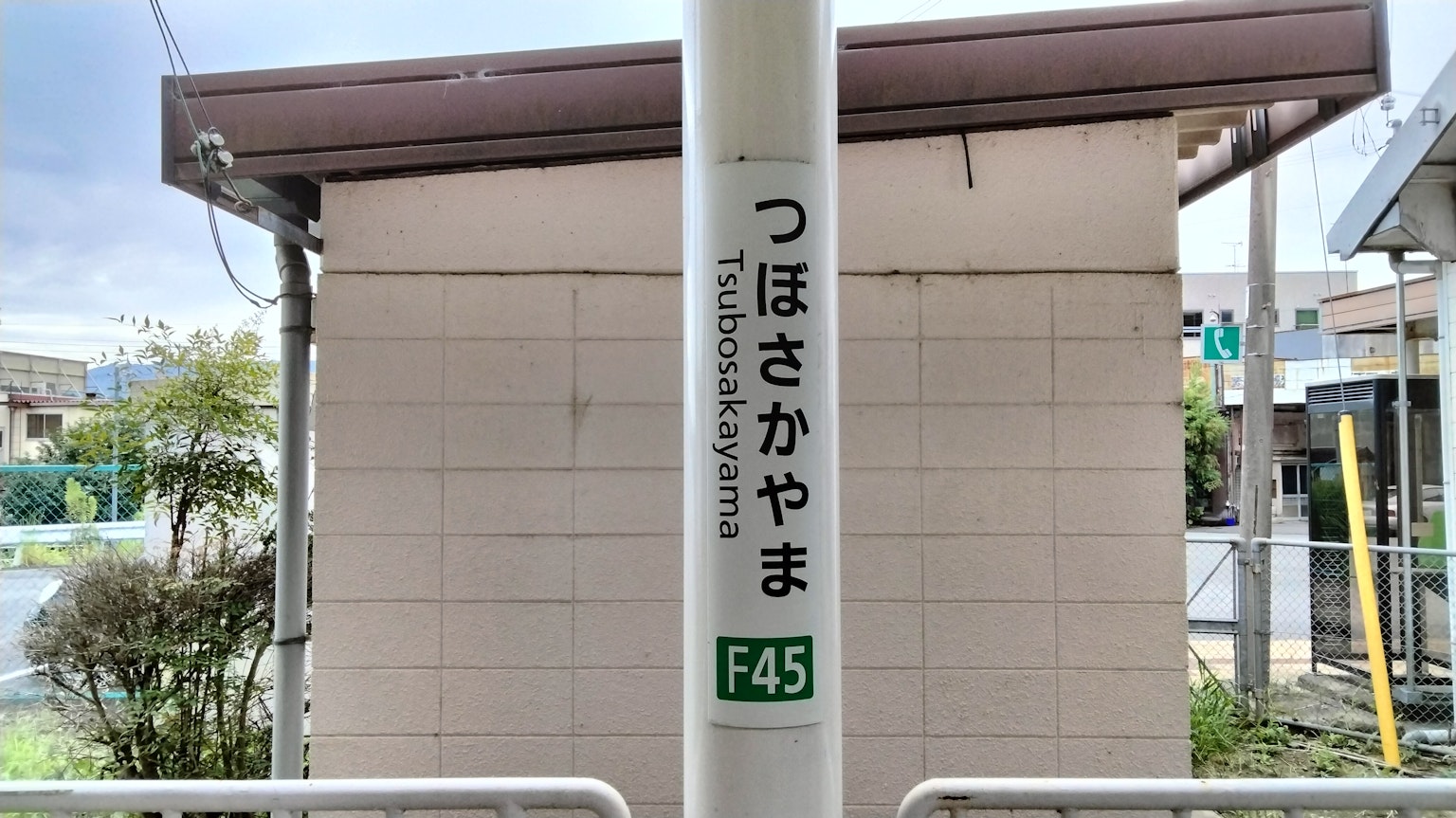 Señal de la estación Tsubosakayama con el paisaje circundante