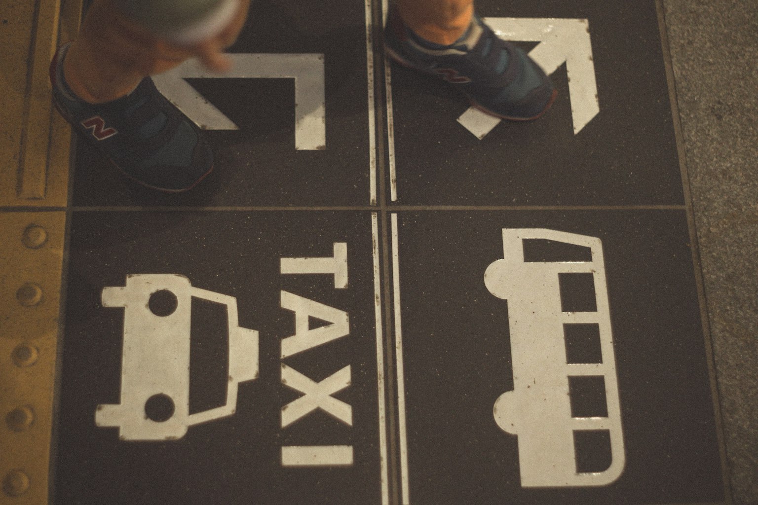 Floor signage featuring taxi and bus icons