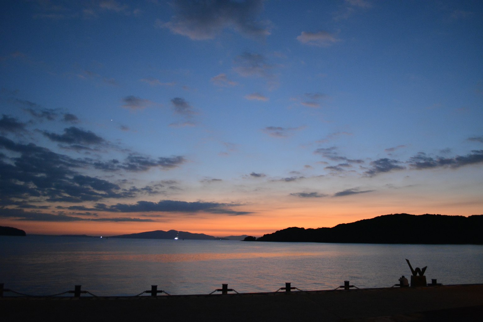 Beautiful landscape with sunset over the sea and mountain silhouettes
