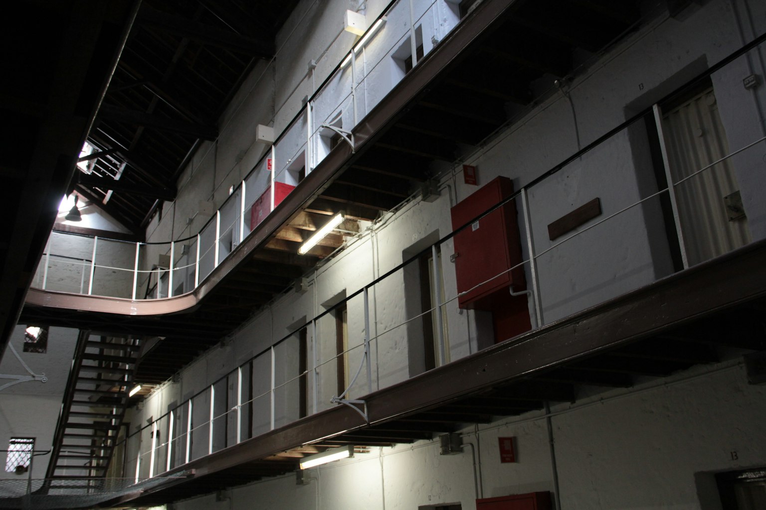Dimly lit prison corridor with prison cells