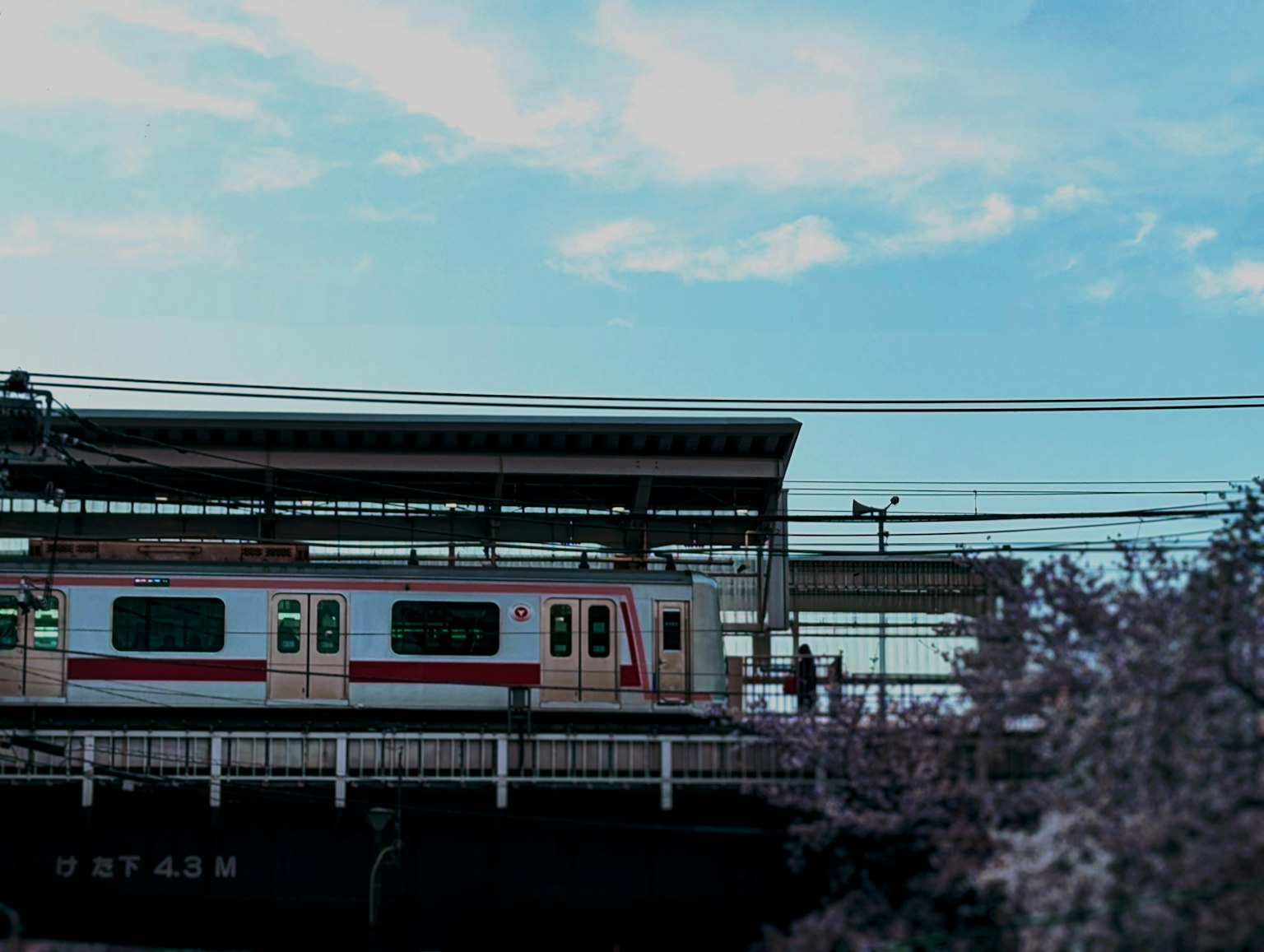 Zug an einer Station unter einem blauen Himmel mit Menschen
