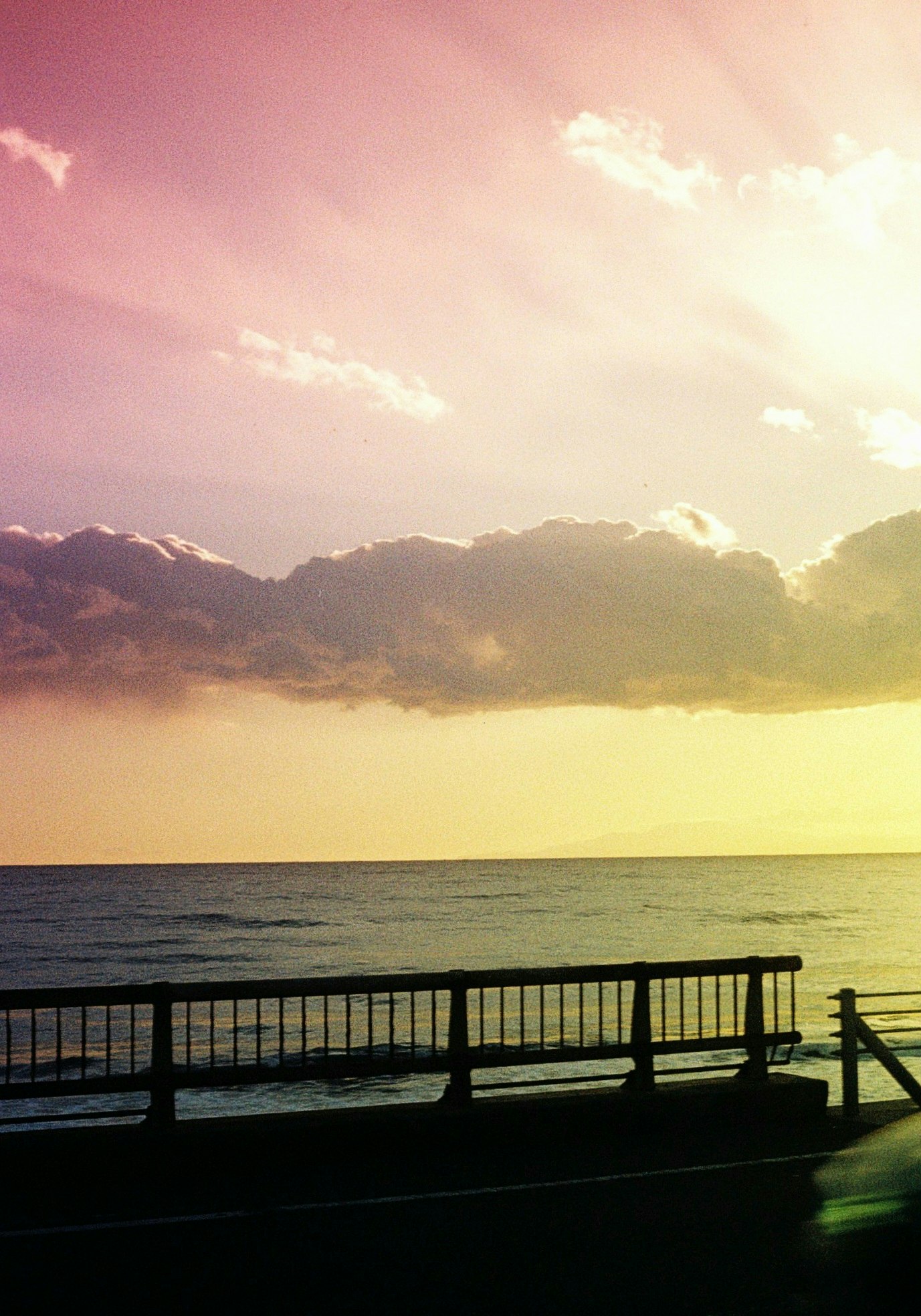 七里ヶ浜の海辺で夕日に照らされる桟橋と波の風景