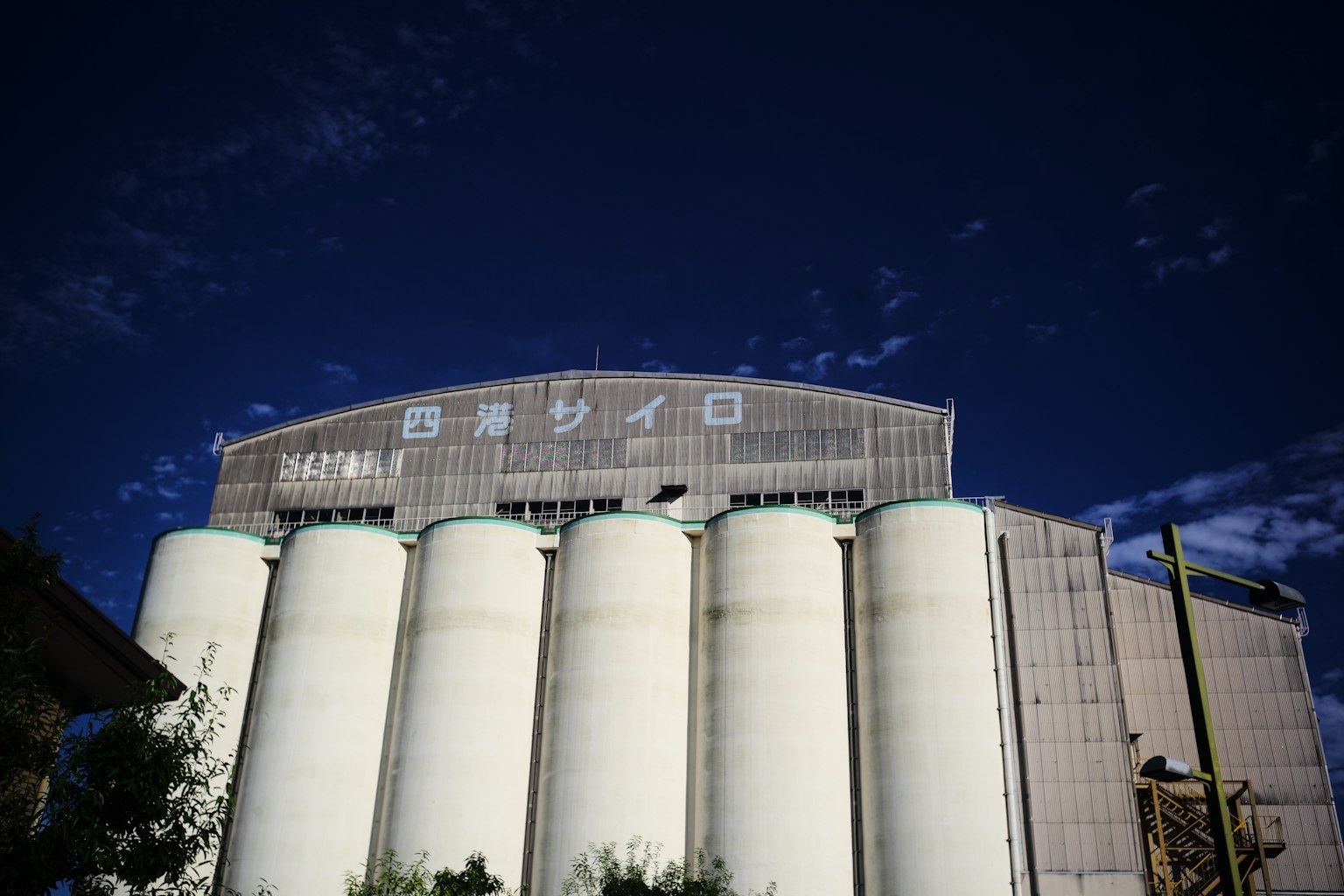 Gran estructura de silo contra un cielo azul con silos cilíndricos