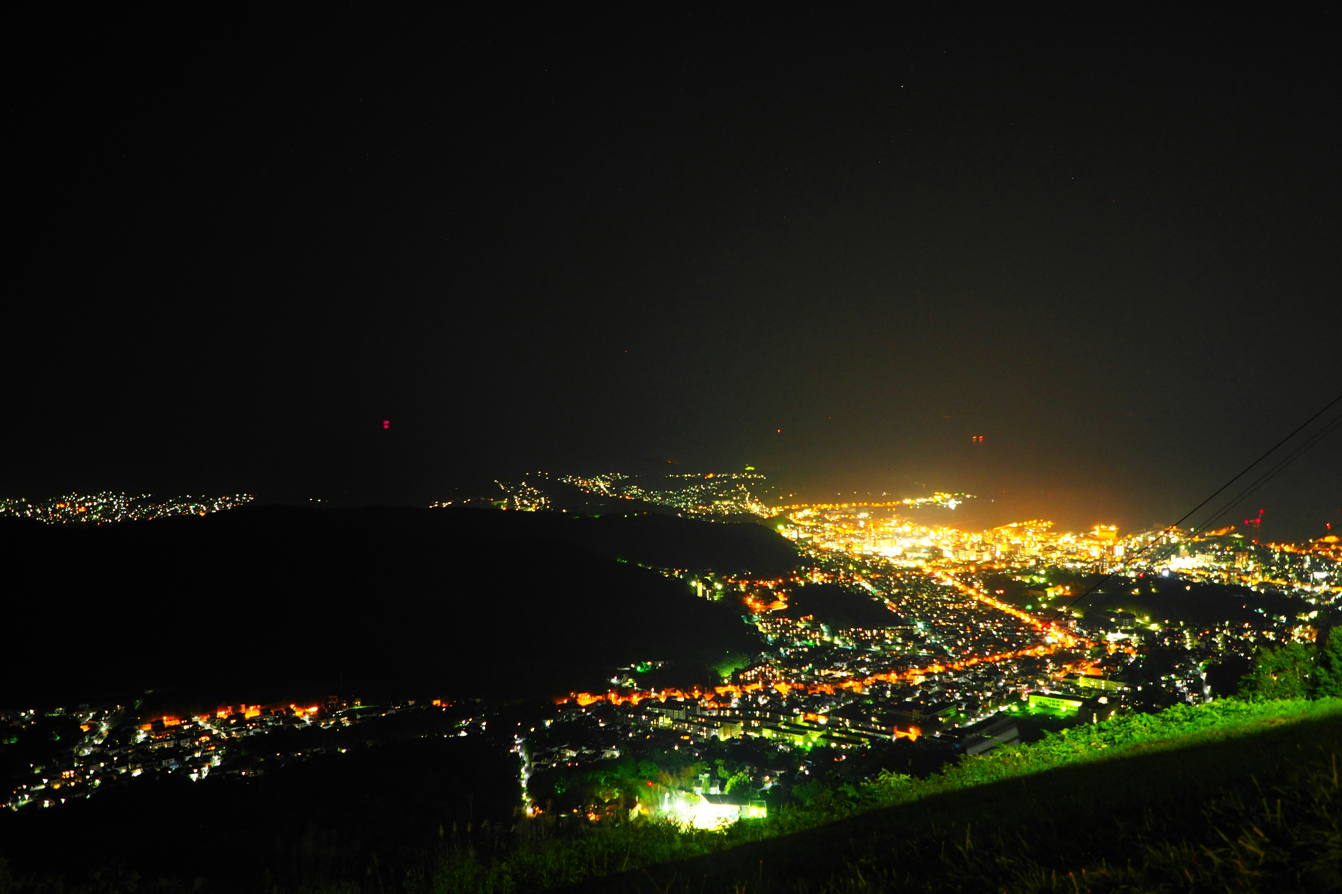 Vista notturna di una città illuminata da una collina