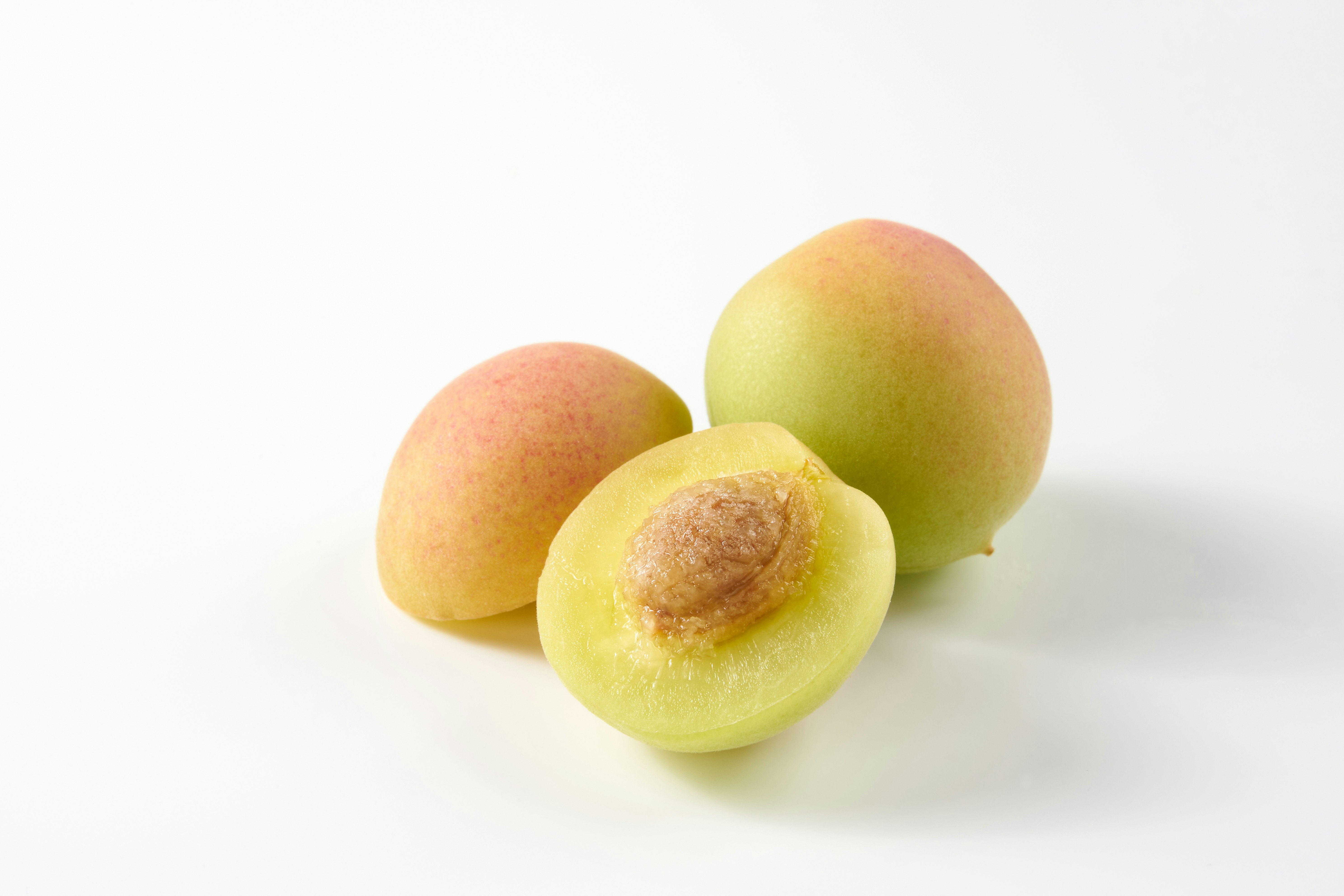 prugne e frutta verde-giallo su sfondo bianco