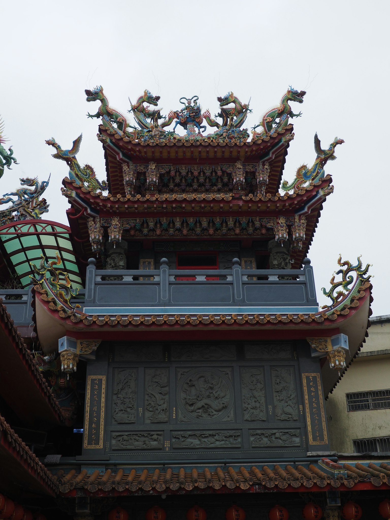 화려한 사원 지붕에 용과 사자 조각이 장식되어 있음