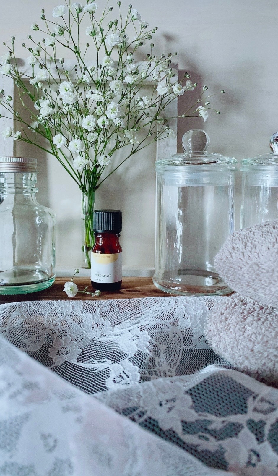 bouteille d’huile essentielle et fleurs fraîches sur une table apaisante