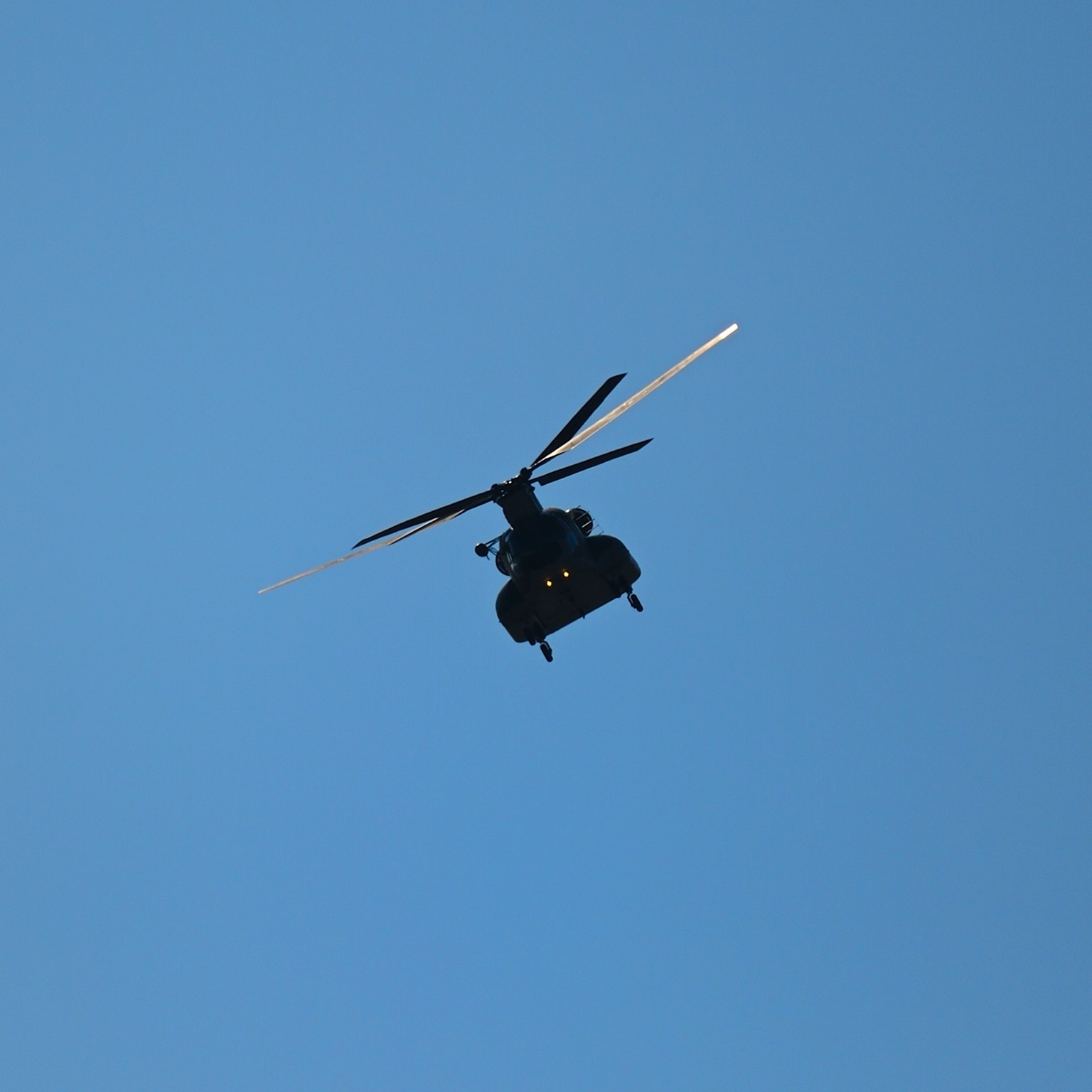 Hélicoptère noir volant contre un ciel bleu