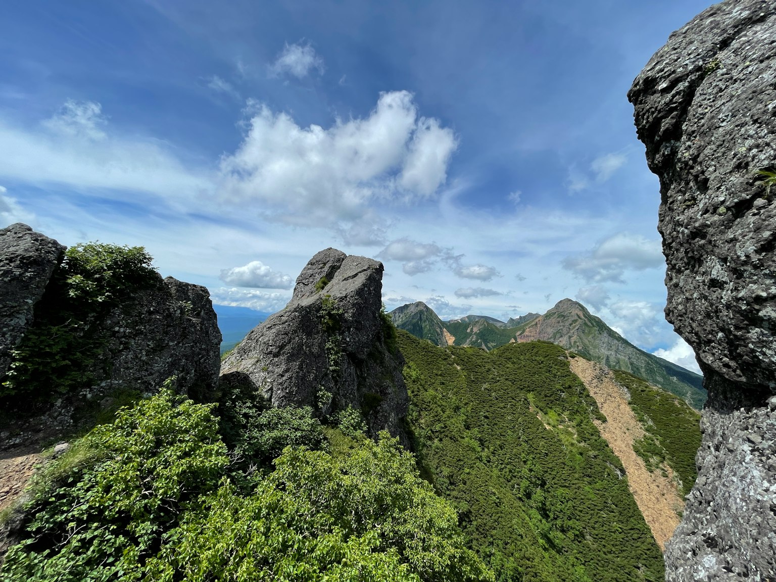 Pemandangan dari puncak gunung bukit hijau subur dan langit biru batu besar yang menonjol