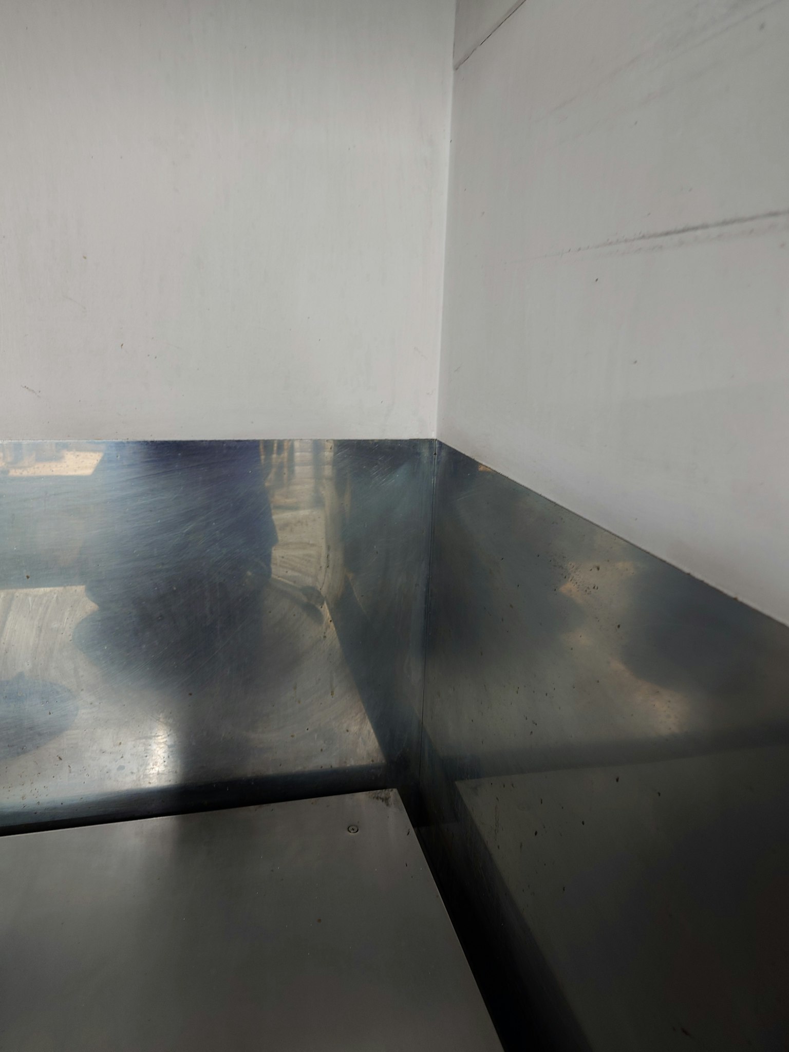 Góc của bàn kim loại và tường trắng