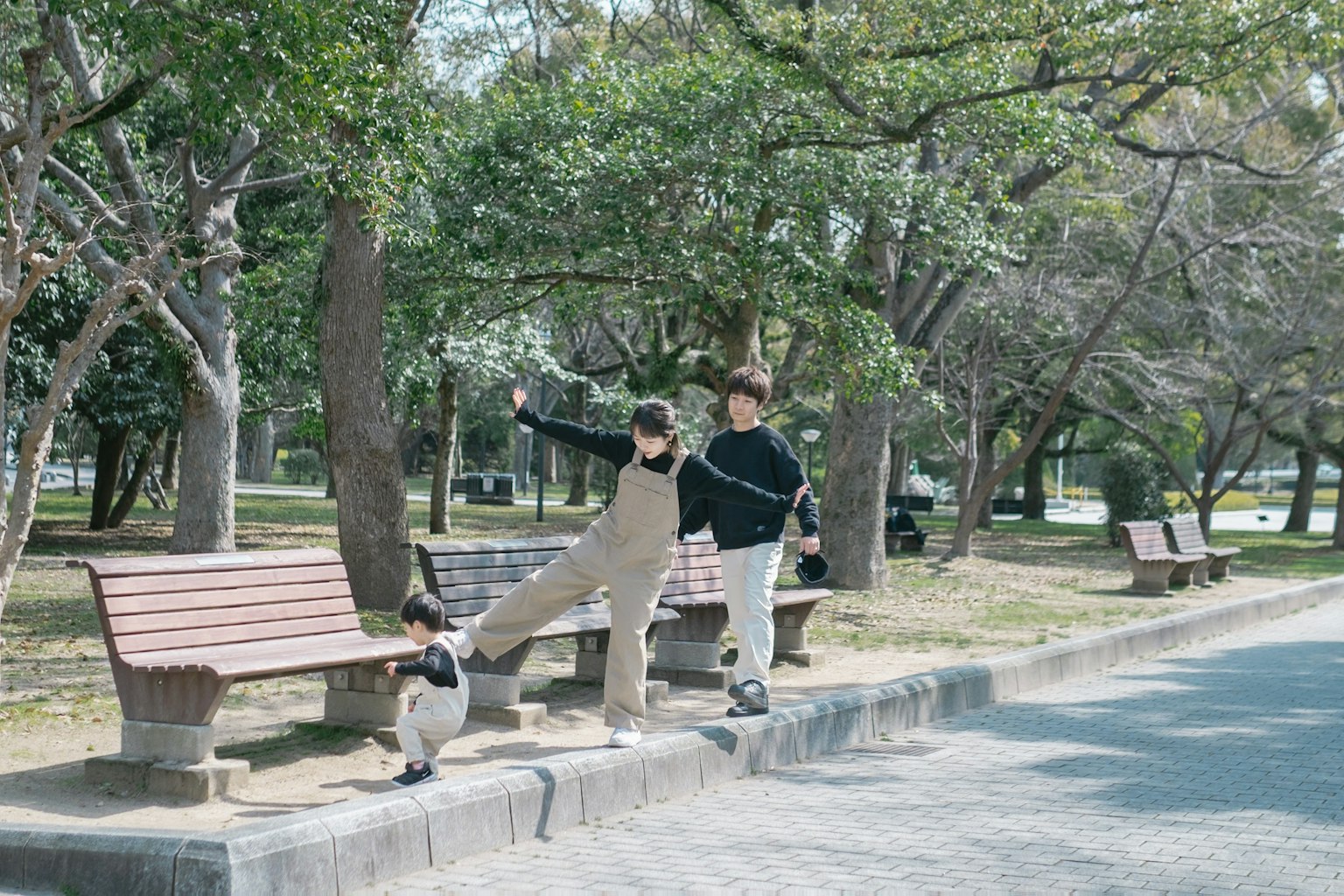 Children playing near benches in a park with a dog