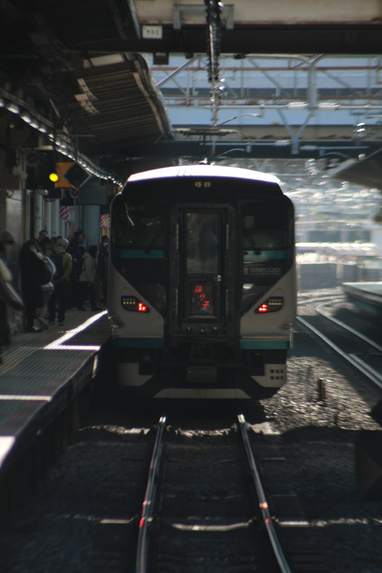 มุมมองด้านหลังของรถไฟที่สถานีพร้อมรางรถไฟ