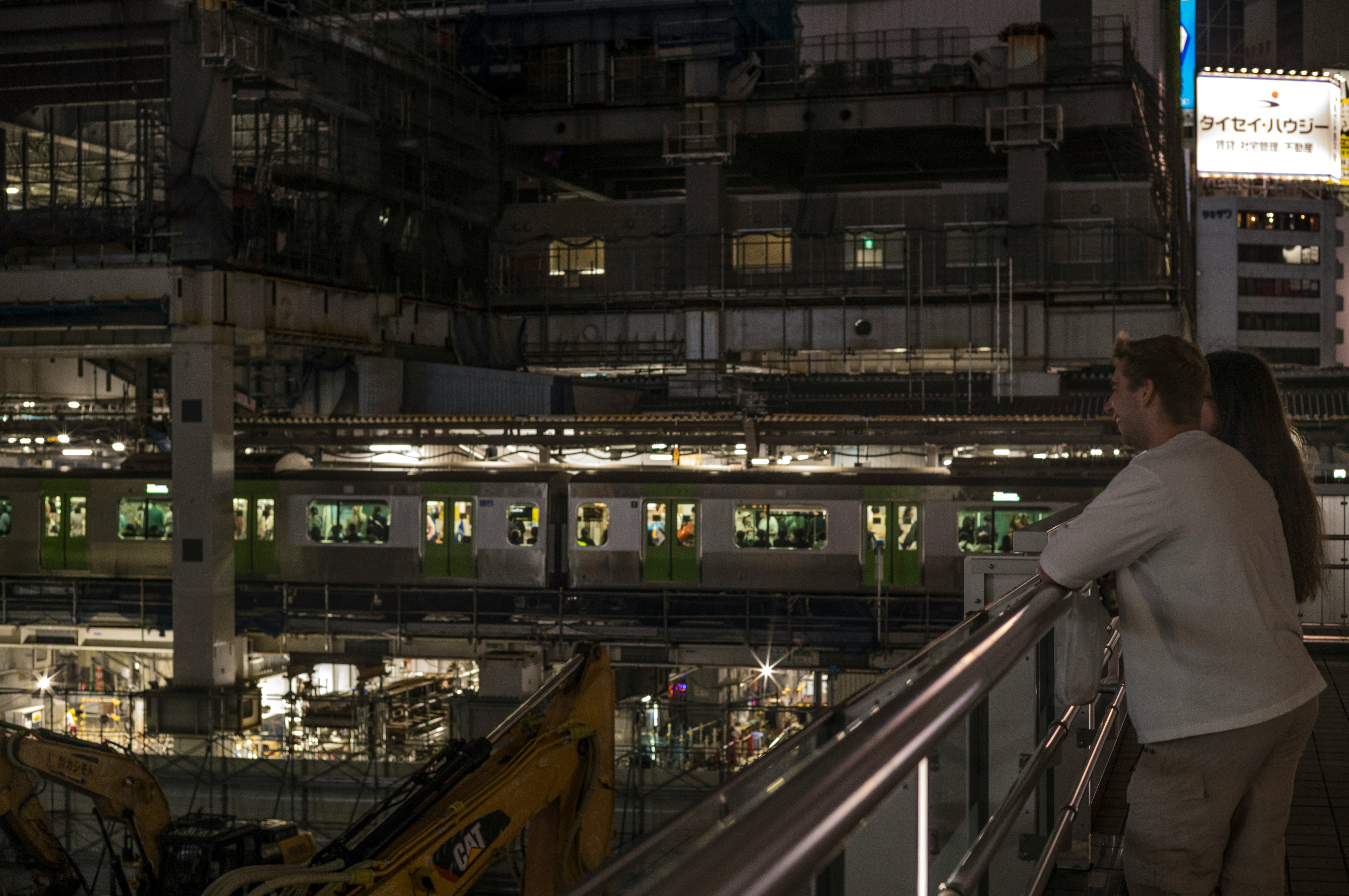 intérieur de gare de nuit avec voies sous une structure surélevée