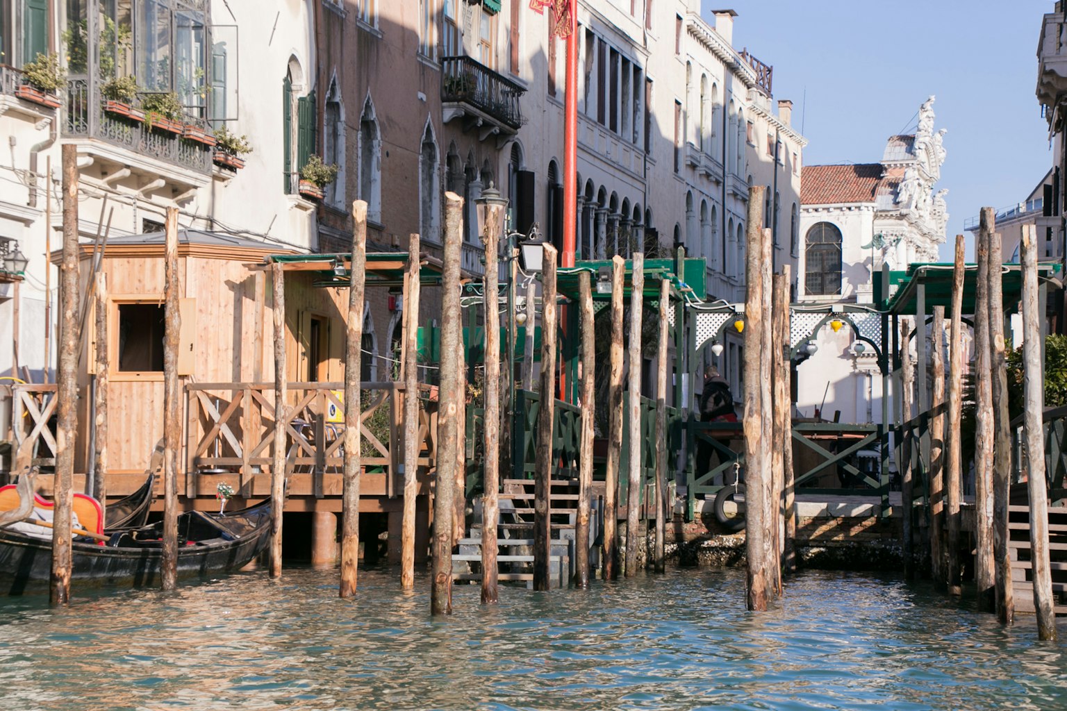 Molo in legno e vecchi edifici lungo un canale a Venezia