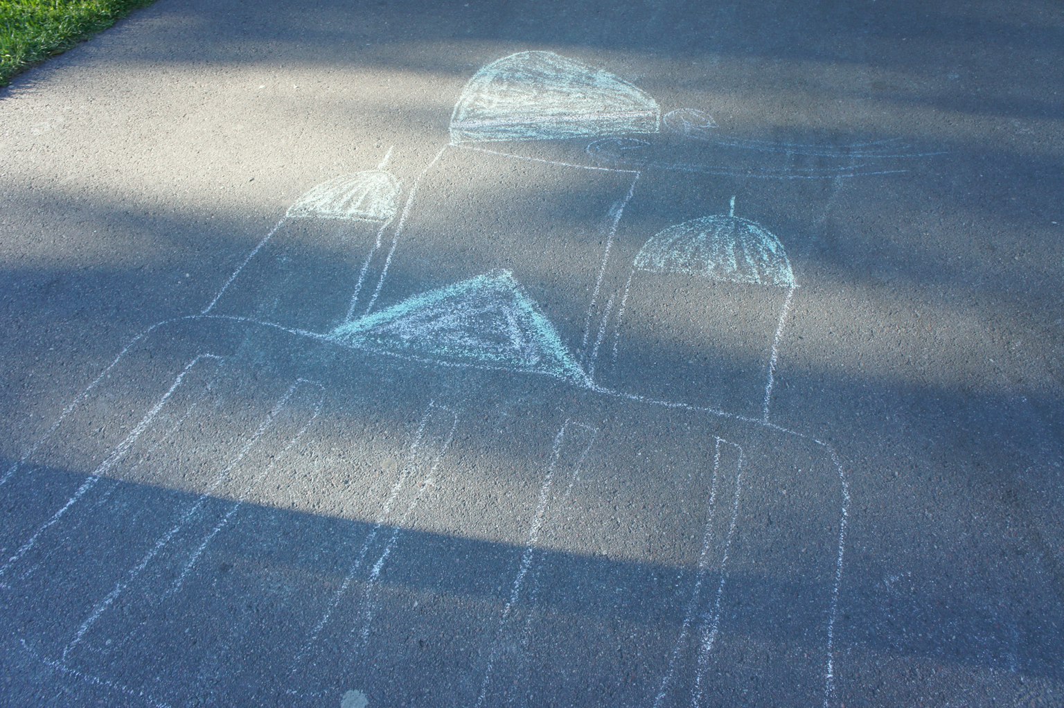 Chalk art sketch of buildings on a sidewalk