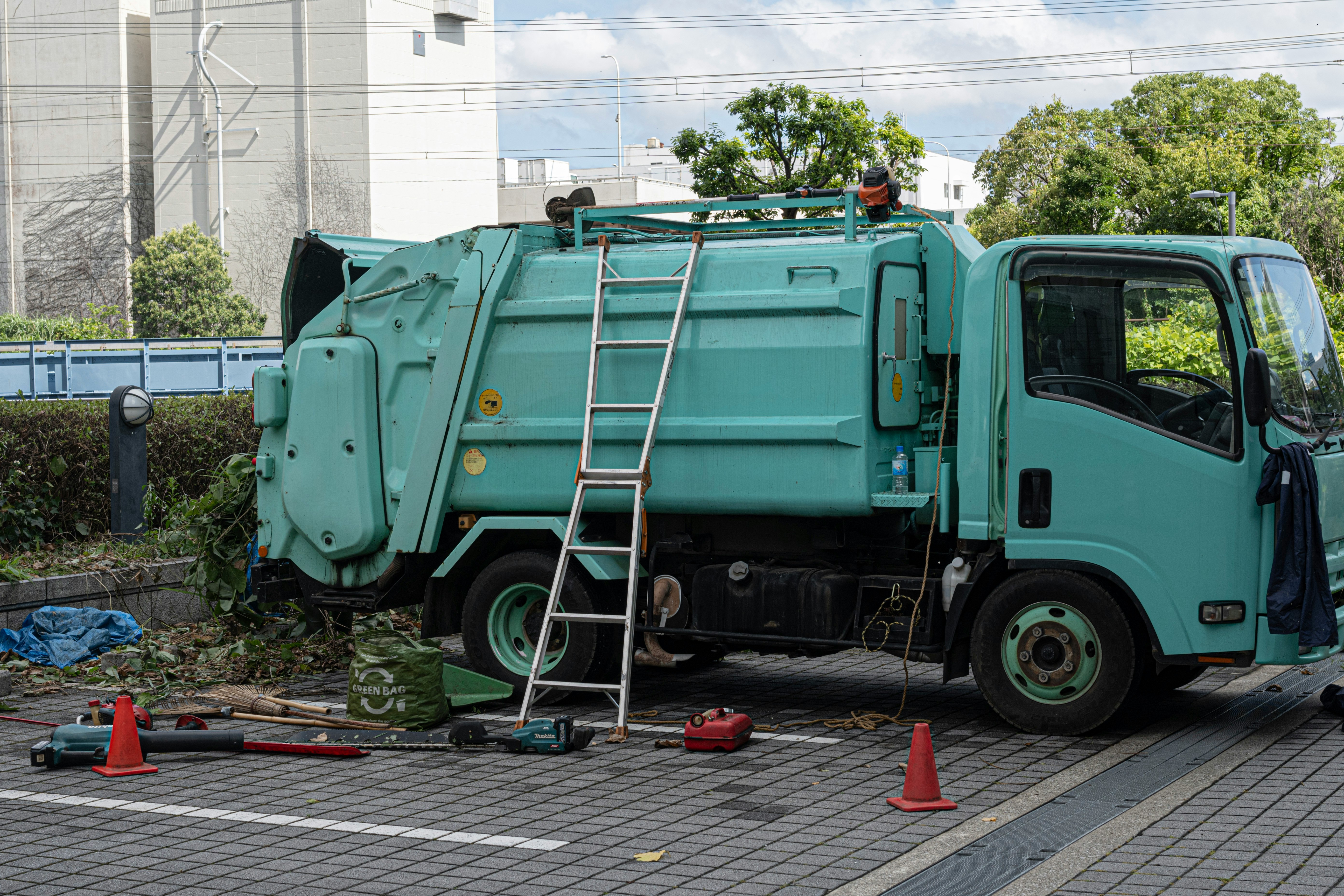 綠色垃圾車在街道上維修