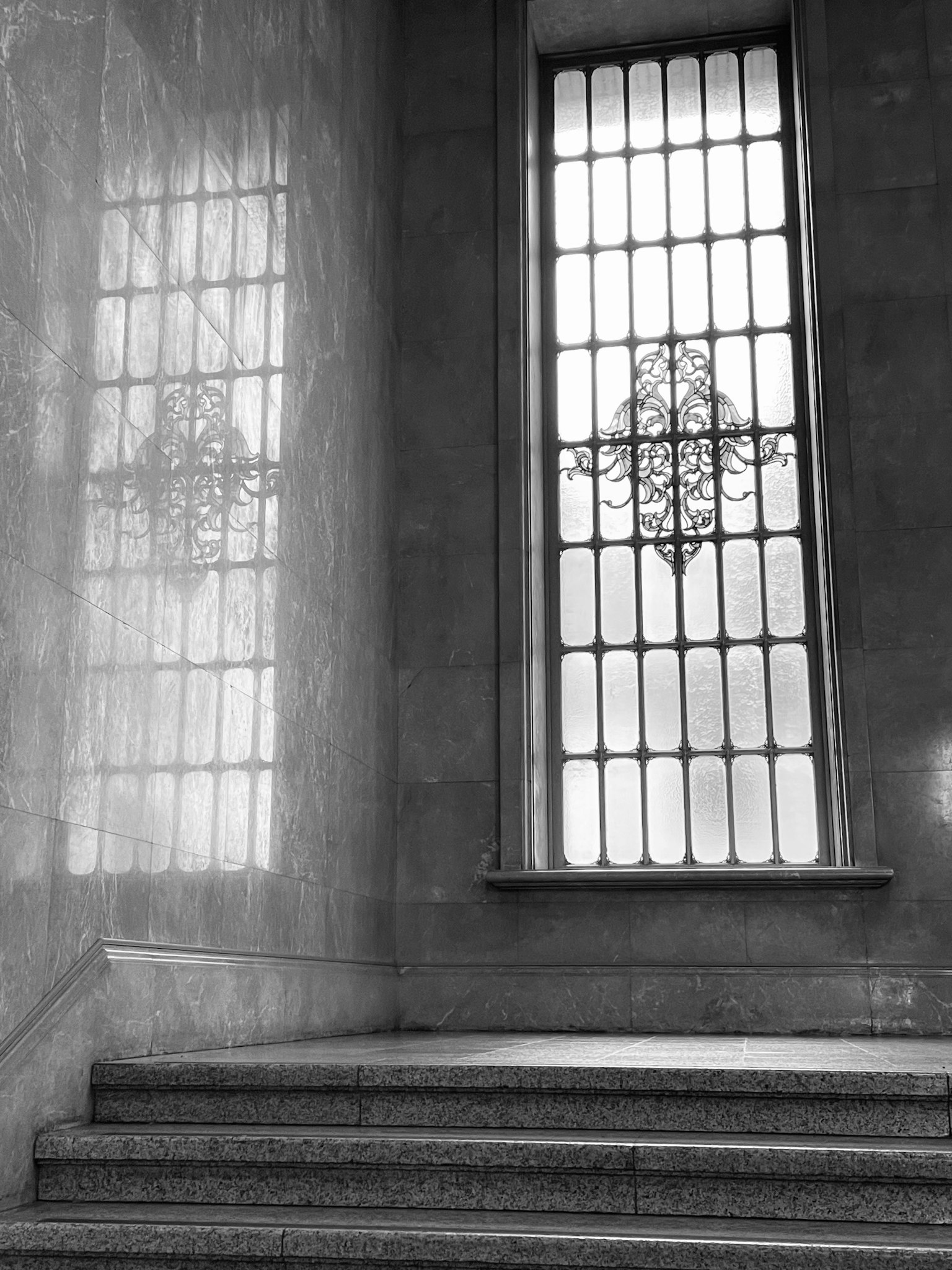Foto d'interno con una grande finestra e riflessi, scala in bianco e nero
