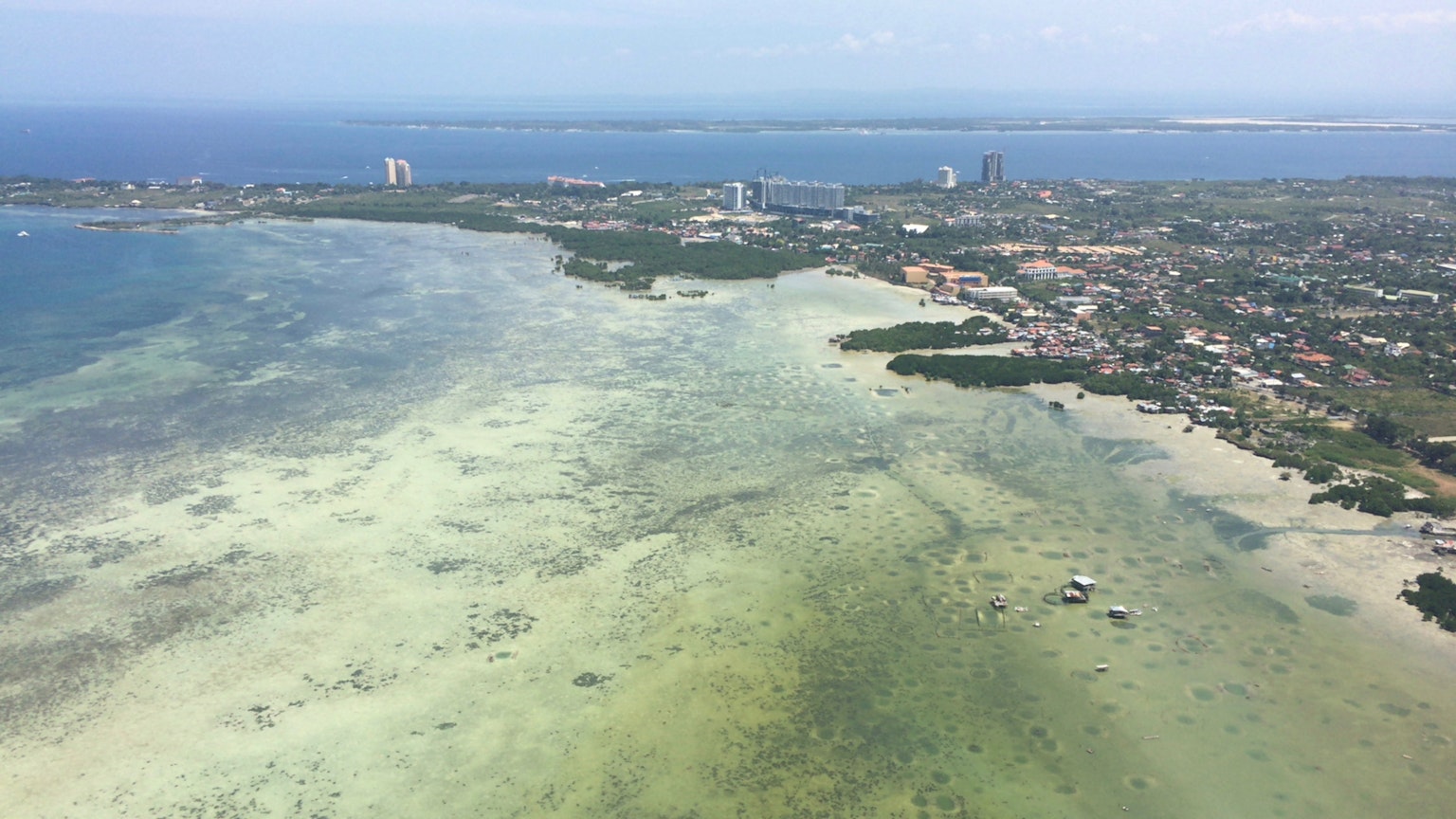 Vue aérienne d'une zone côtière avec de l'eau claire et un développement urbain