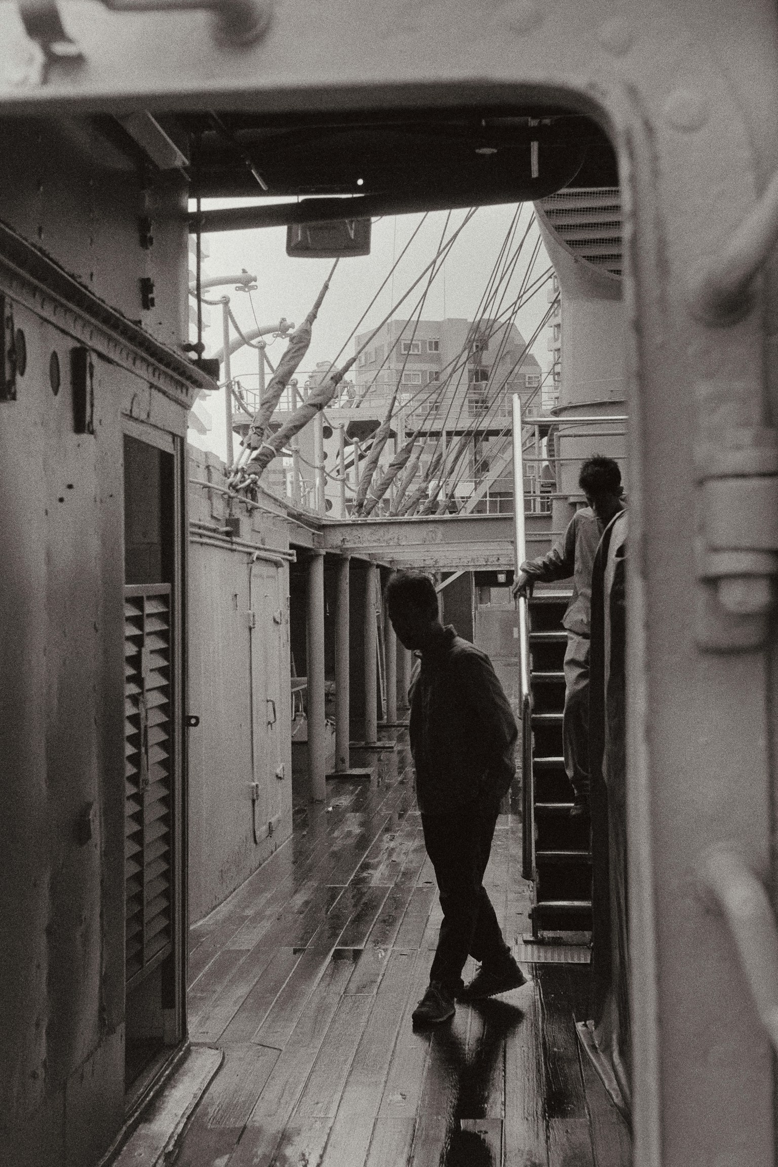 Una persona caminando en el pasillo de un barco con escaleras al fondo