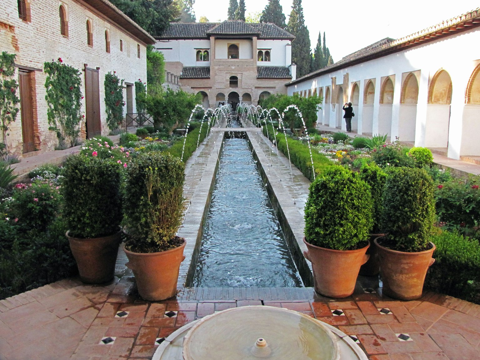 Pemandangan indah taman di Istana Alhambra dengan air mengalir dan vegetasi subur