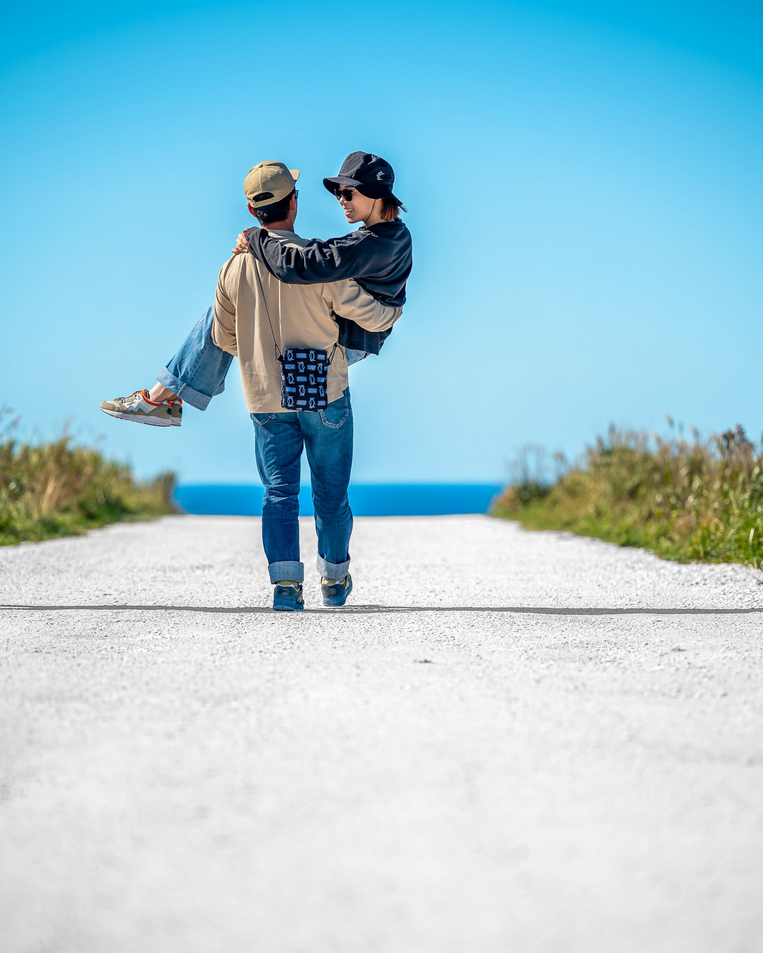 Dos personas con ropa casual caminando por un camino de playa