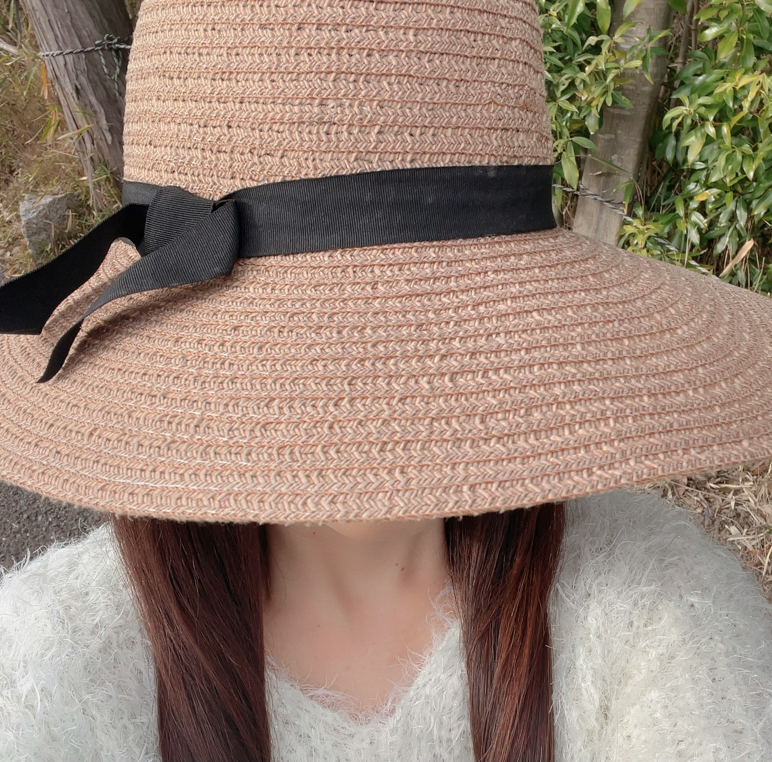 一位女性戴著黑色絲帶的大草帽的圖像