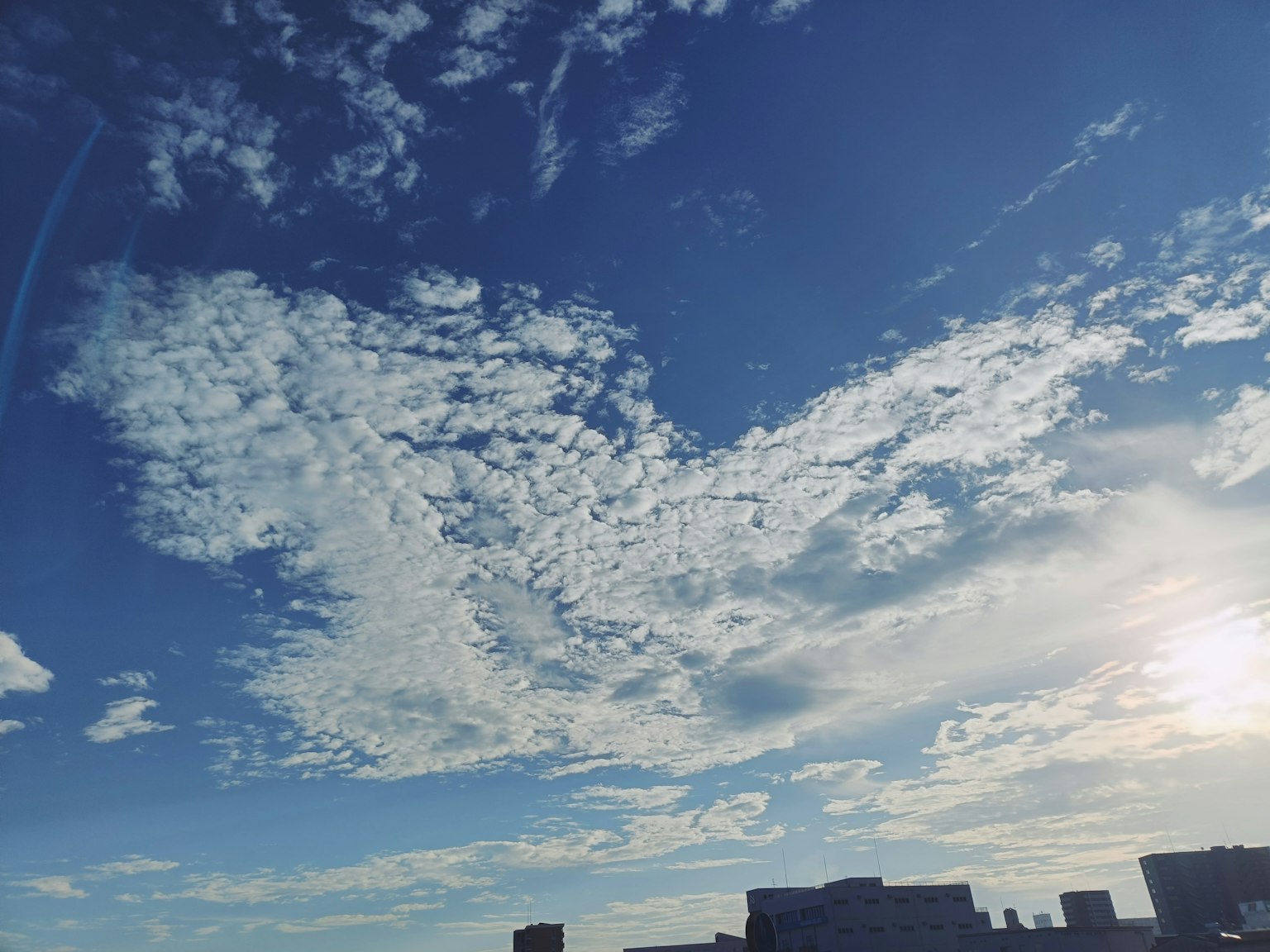 青空に浮かぶ白い雲と夕日が映える風景