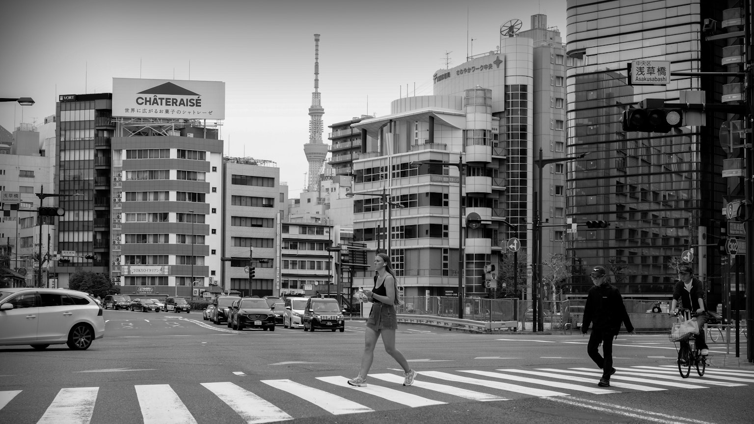 Photographie en noir et blanc de piétons traversant une rue à Tokyo