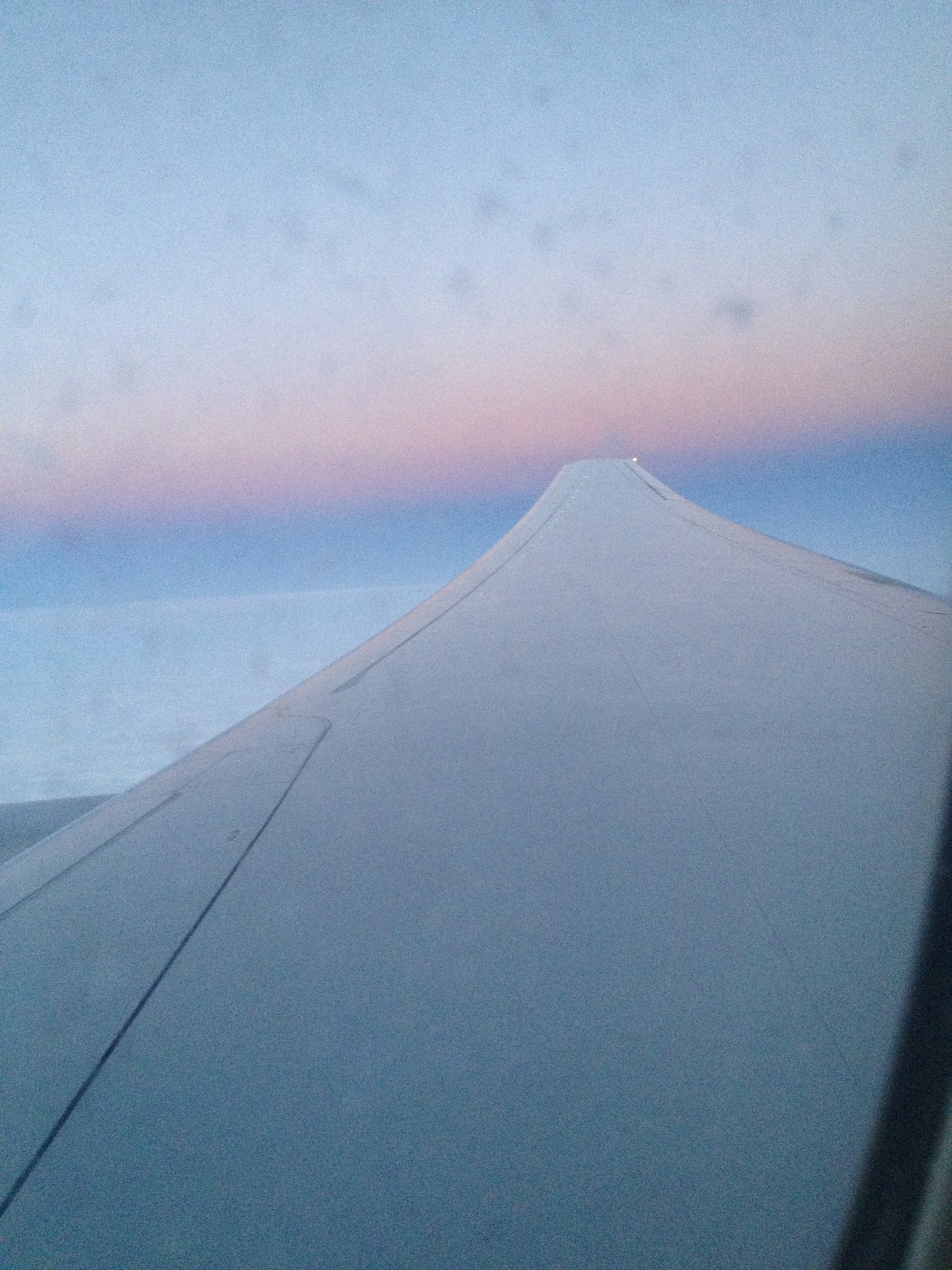 ภาพถ่ายที่จับภาพปีกเครื่องบินและสีท้องฟ้าที่สวยงาม