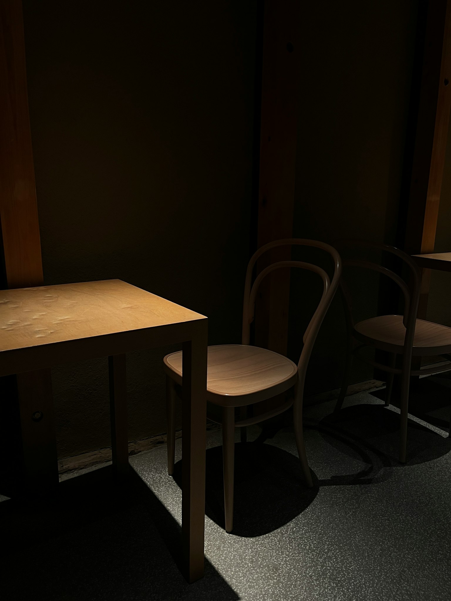 Wooden table and chairs in a dimly lit room