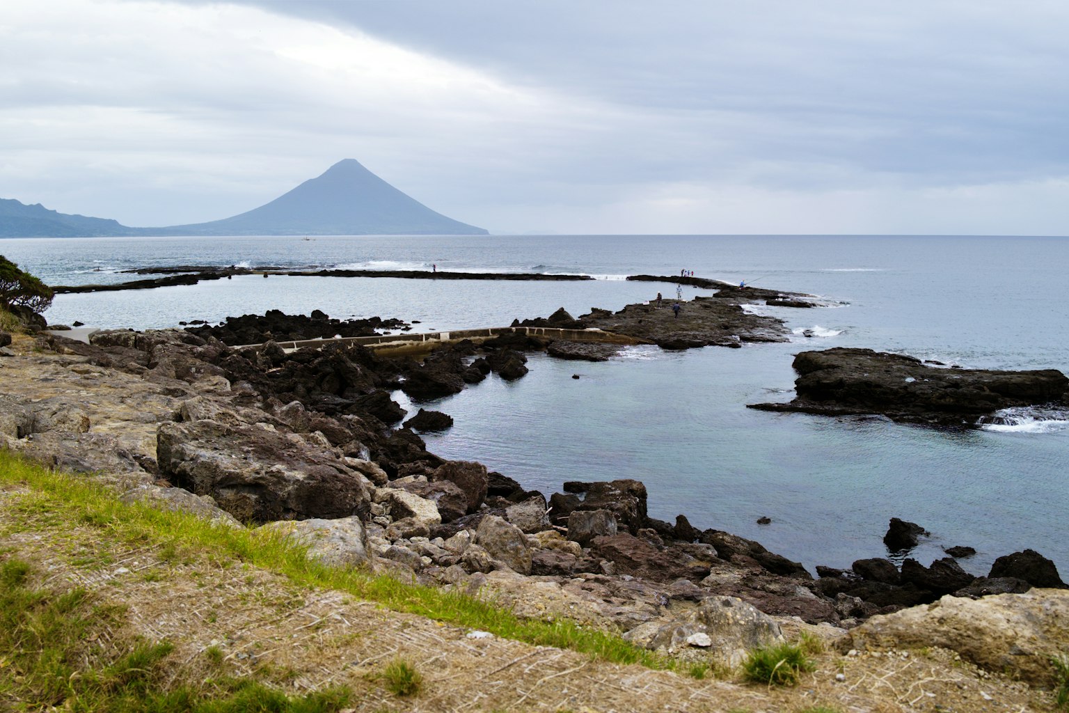 Coastal landscape with rocky shores and a mountain in the background
