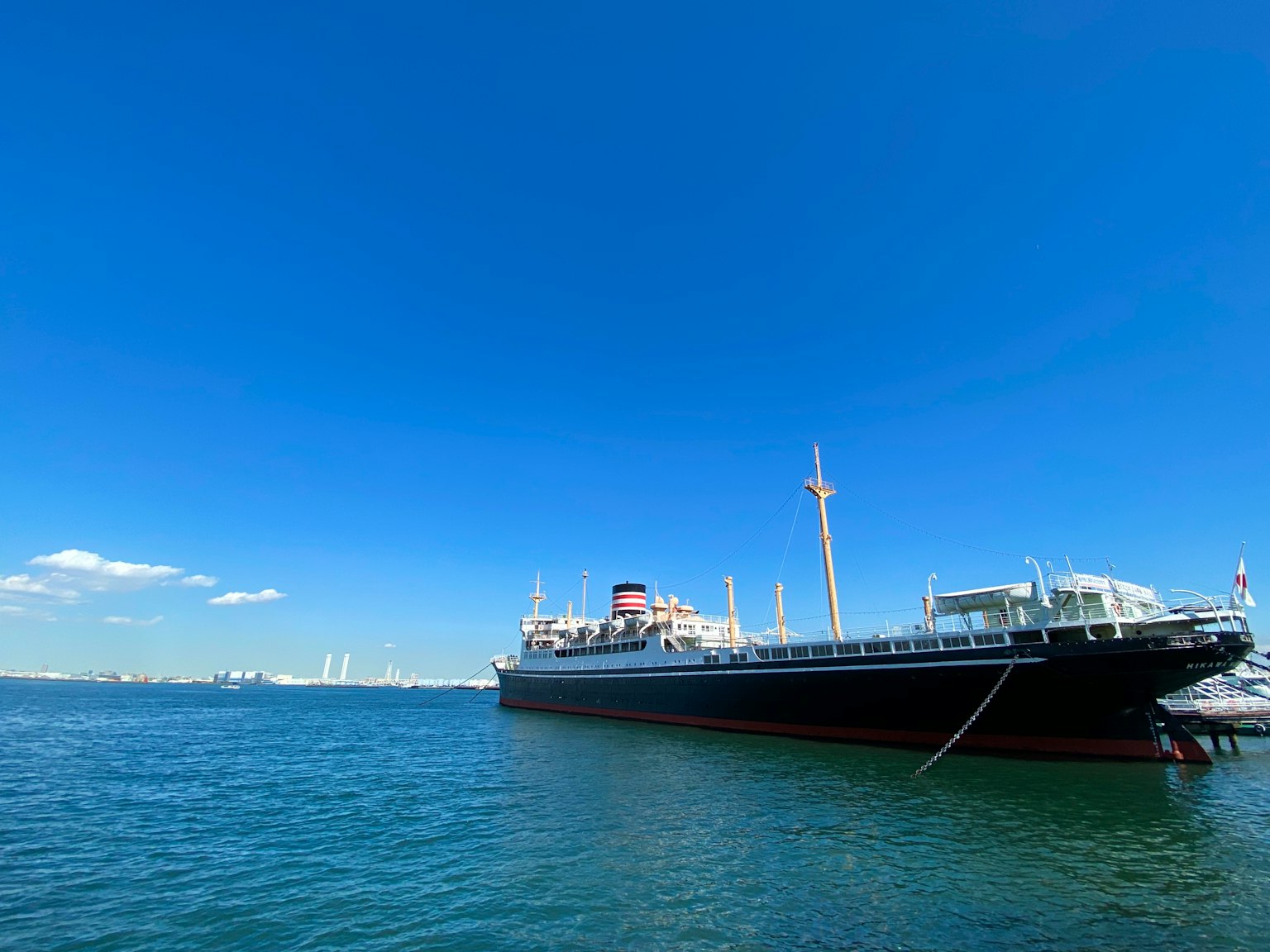 Large ship docked under a clear blue sky with expansive ocean