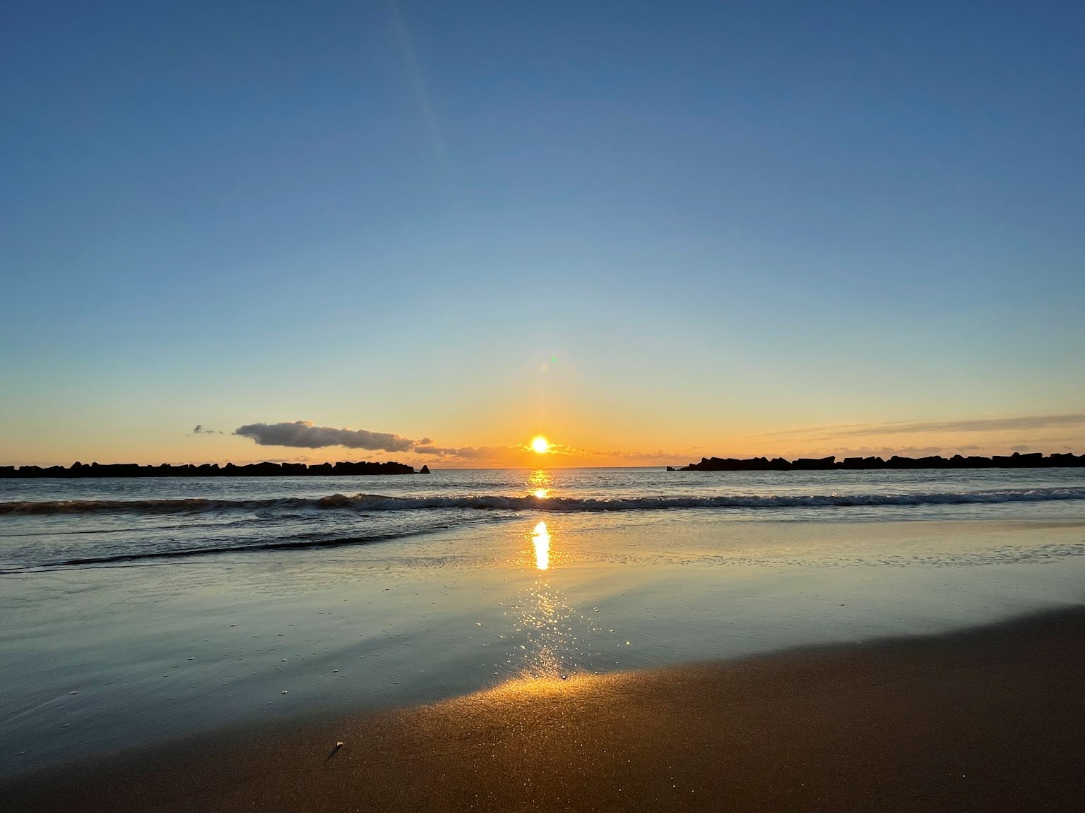 Scena di spiaggia serena con un bellissimo tramonto che si riflette sull'acqua