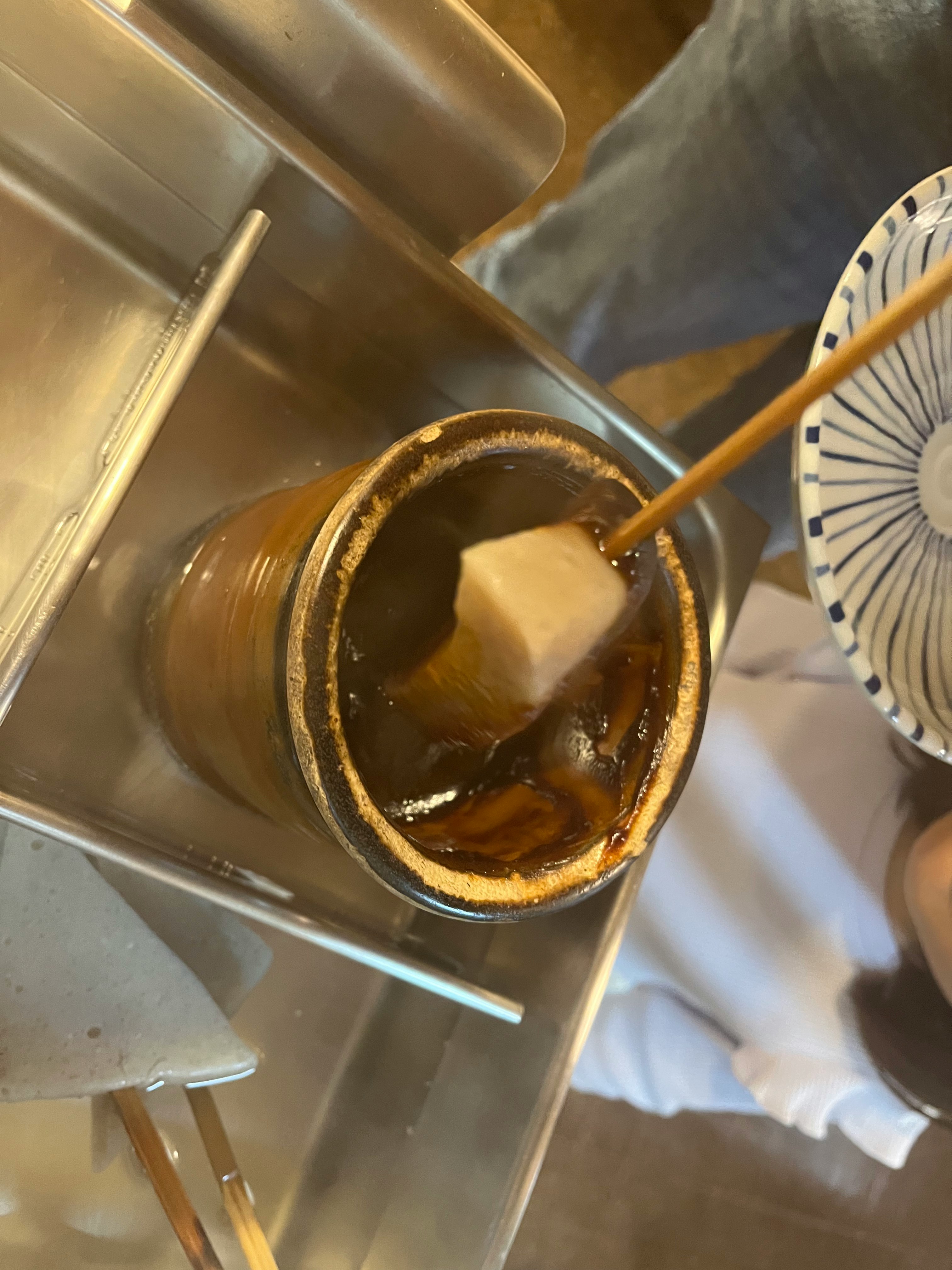 coffee being poured into a cup with sugar cubes