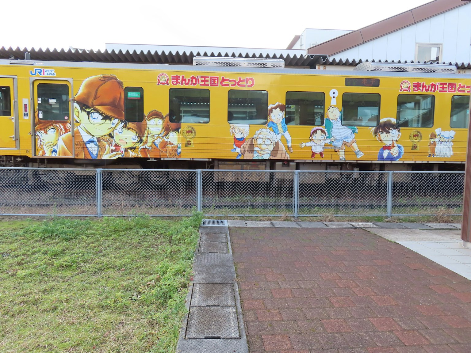 Yellow train adorned with anime character illustrations